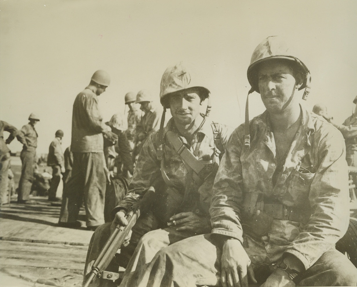 Southerners in Fray, 12/1/1943. Tarawa, G.I. - - Both Southerners, both Marines, Lt. Cecil Brown (L), 27, of Tallassee, Alabama, and Lt. Roy H. Elrod, 24, of Muleshier (??- - - postal guide lists no such town, but does list Muleshoe), Texas, rest on a pier after successful assault against Japanese of Tarawa.  Even while resting Lt. Brown keeps his rifle at the ready.Credit (ACME);