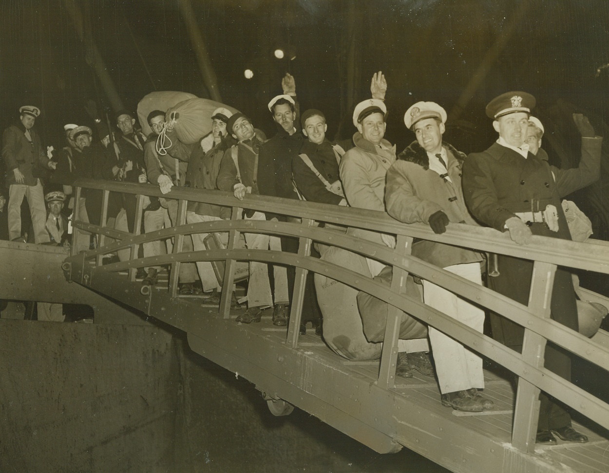 Back On American Soil, 12/17/1943. New York City – Commander Wallace L. Rinehart of St. Louis, MO., Commander of the 54th U.S. Navy Construction Battalion leads a gang of jubilant Seabees down the Gangplank of a Navy transport to set foot on American soil for the first time in ten months. With an excellent record of service in the Mediterranean behind them, the Seabees returned to the States today (Dec. 17th). The boys went directly to Camp Endicott, R.I., where every CB man will be granted Christmas leave.;
