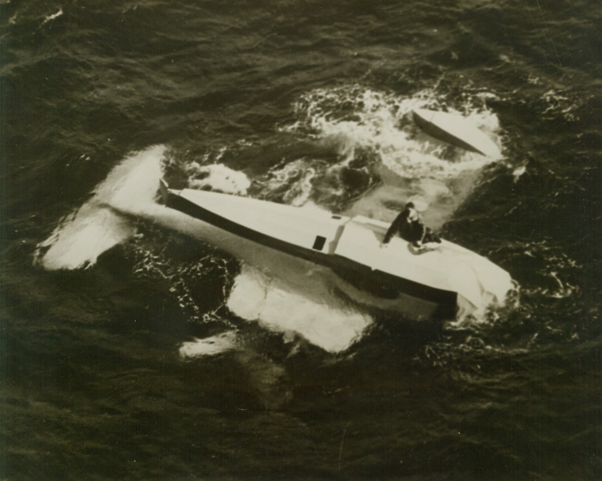 Blimp Rescues Downed Flier - (#1), 12/23/1943. Somewhere on the Atlantic - Aviation Mate 3/c Charles J. Schultz, clings to the pontoon of his overturned Curtiss Observation Plane, after being forced down “somewhere on the Atlantic”. This photo, just released in the United States, was taken from the U.S. Navy Blimp K-89, which dropped a life raft to the flier. The pilot of the plane, Ensign Arthur Masley, USNR, Batavia, Ill., was trapped in the overturned craft and killed. (See photo 708044). Credit: U.S. Navy photo from ACME;