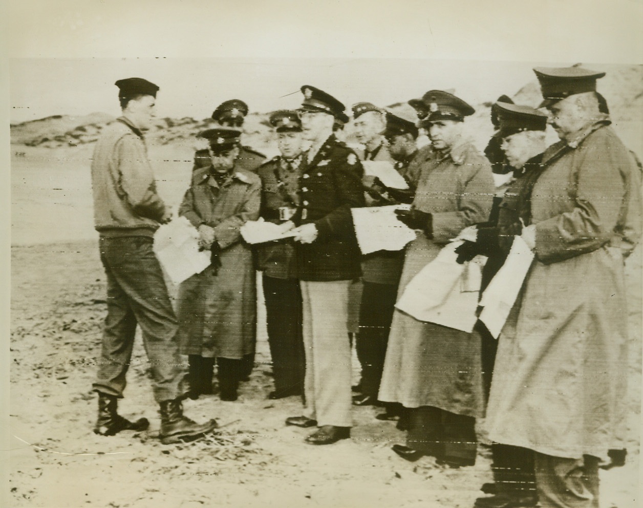 Brazilian Army Men in North Africa, 12/14/1943. North Africa—Members of the Brazilian-U.S. Joint Defense Commission listen to Maj. Dudley Williams give a resume of the Allied invasion of Algeria at St. Eugene, Algiers, one of the landing points. Prominent in the group are: Gen. Mascarenhas and Gen. Anor of the Brazilian Army and Maj. Gen. J.G. Ord, U.S. Army member of the Commission. Officer at extreme left acts as interpreter. Credit: Signal Corps radiotelephoto from ACME.;