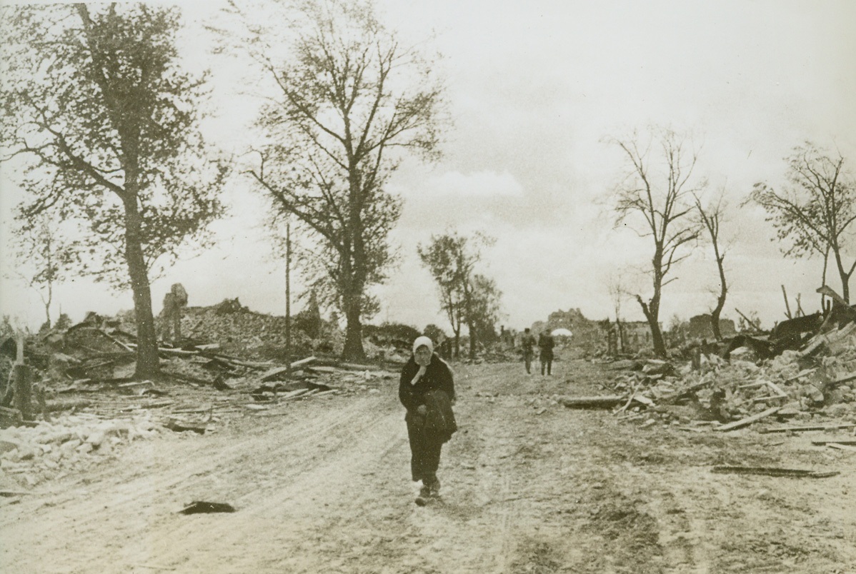 Main Street, 12/14/1943. New York City—A Russian peasant woman does no visiting or “shopping” on the main street of Zhizdra, a town liberated from the Germans. Retreating Nazis used a hit and run policy, burning and razing a town before they retreat. Credit: ACME.;
