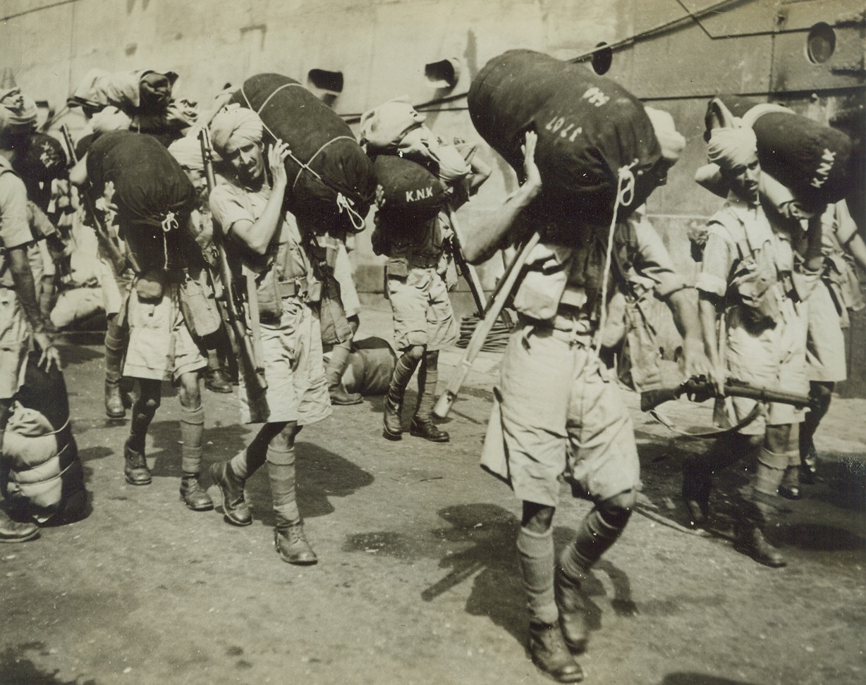 Indian Troops Arrive in Singapore, 1/2/1942. Singapore – Indian troops march to their billets after arriving in Singapore, December 21. They are mostly Punjabs and Southern Indians. In the photo, they have just been dismissed after an inspection upon arrival in the city. (Passed by British censor.) Credit: ACME;