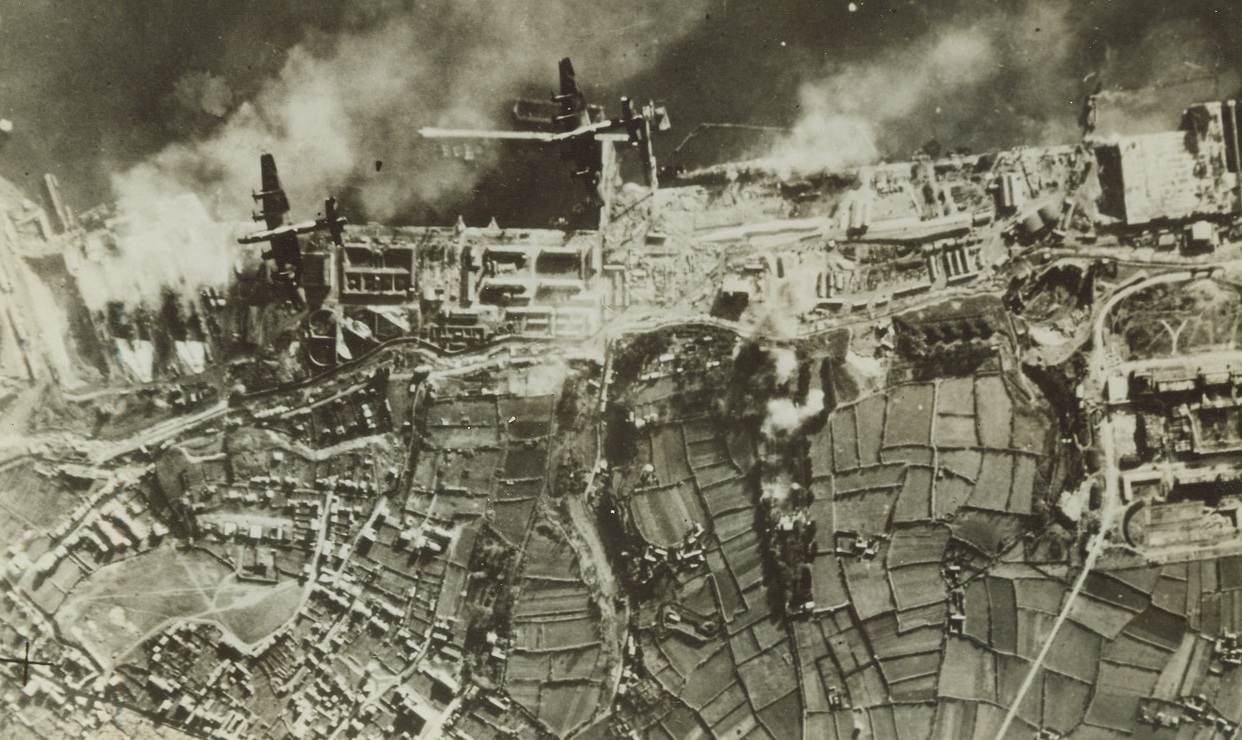 Daylight Raid on Brest, 1/3/1942. Brest - Here is an air view of the recent daylight bombing of Brest. Two 4-motored Halifax Bombers of the RAF Bomber Command can be seen pressing home their attack on the German Pocket Battleships Sharnhorst and Gneisenau, which were in drydock (at left). The Germans sent up a smoke screen in an effort to obscure the target. It wasn’t very effective. Passed by British Censor Credit: ACME;