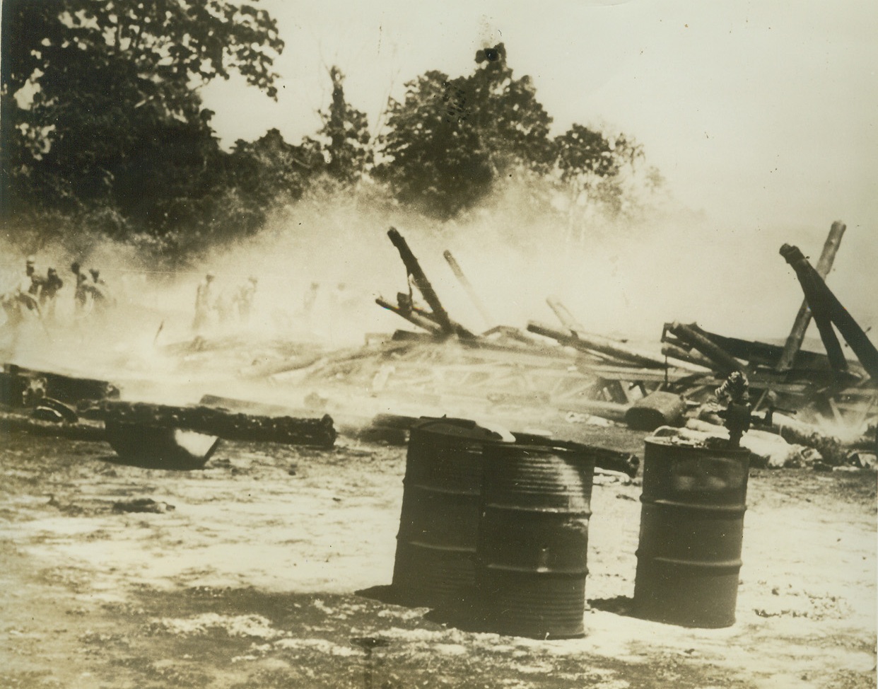 BATTLE RAGING IN THE SOLOMONS, 10/15/1942. United States Forces are striving to prevent the Japanese from landing reinforcements on Guadalcanal. The above photo just released by the US Navy shows—when a Japanese bomber scored a direct hit on this airplane hangar. The Japs are now intensifying their attacks on American positions, but at heavy cost. Credit: US Navy official photo from Acme;