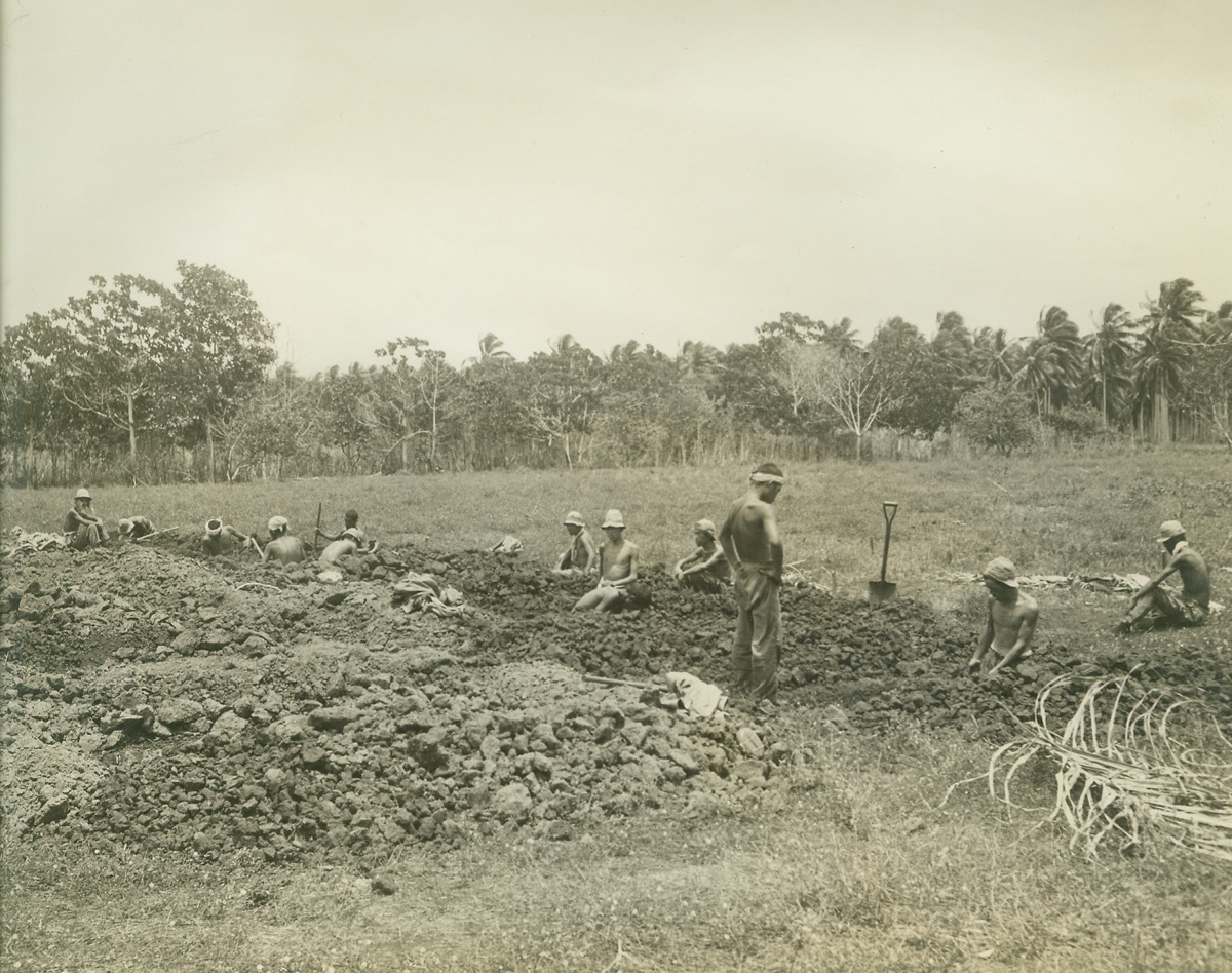CAPTURED JAPS AT WORK ON GUADALCANAL, 10/17/1942. SOLOMON ISLANDS—Japs captured by the U.S. Marines on Guadalcanal are made to earn their keep. Here members of a Jap prisoner labor unit are shown preparing graves for those who have fallen in battle. Credit: Acme;