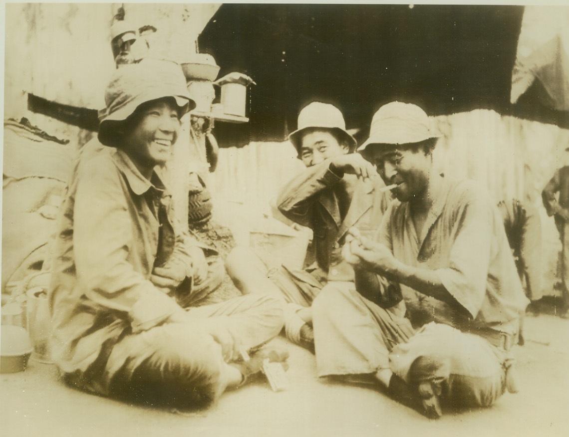 BEING U.S. PRISONER LOOKS LIKE GOOD STUFF, 10/19/1942. SOMEWHERE ON GUADALCANAL ISLAND – Japanese prisoners of war seem anything but unhappy as they light up American-made cigarettes, of which, incidentally, they receive 10 a day. The Nips were nabbed in the recent fierce Solomon Island action. Credit: ACME;