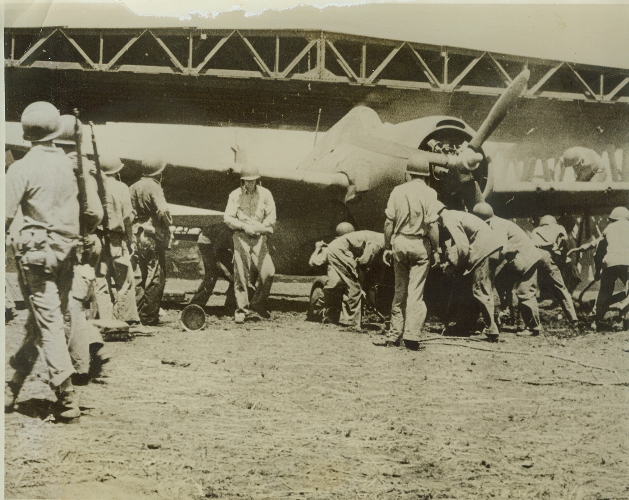 U.S. Plane Salvaged From Jap-Bombed Hangar, 10/21/1942. This photo, which has just been released and which is from an official U.S. Marine Corps newsreel, shows American marines salvaging a plane from a blazing hangar at Henderson Field on Guadalcanal Island, after a recent Jap bombing raid on that strategic key point of the U.S. defenses in the Solomon Islands. Credit: (U.S. Marine Corps Photo from ACME);