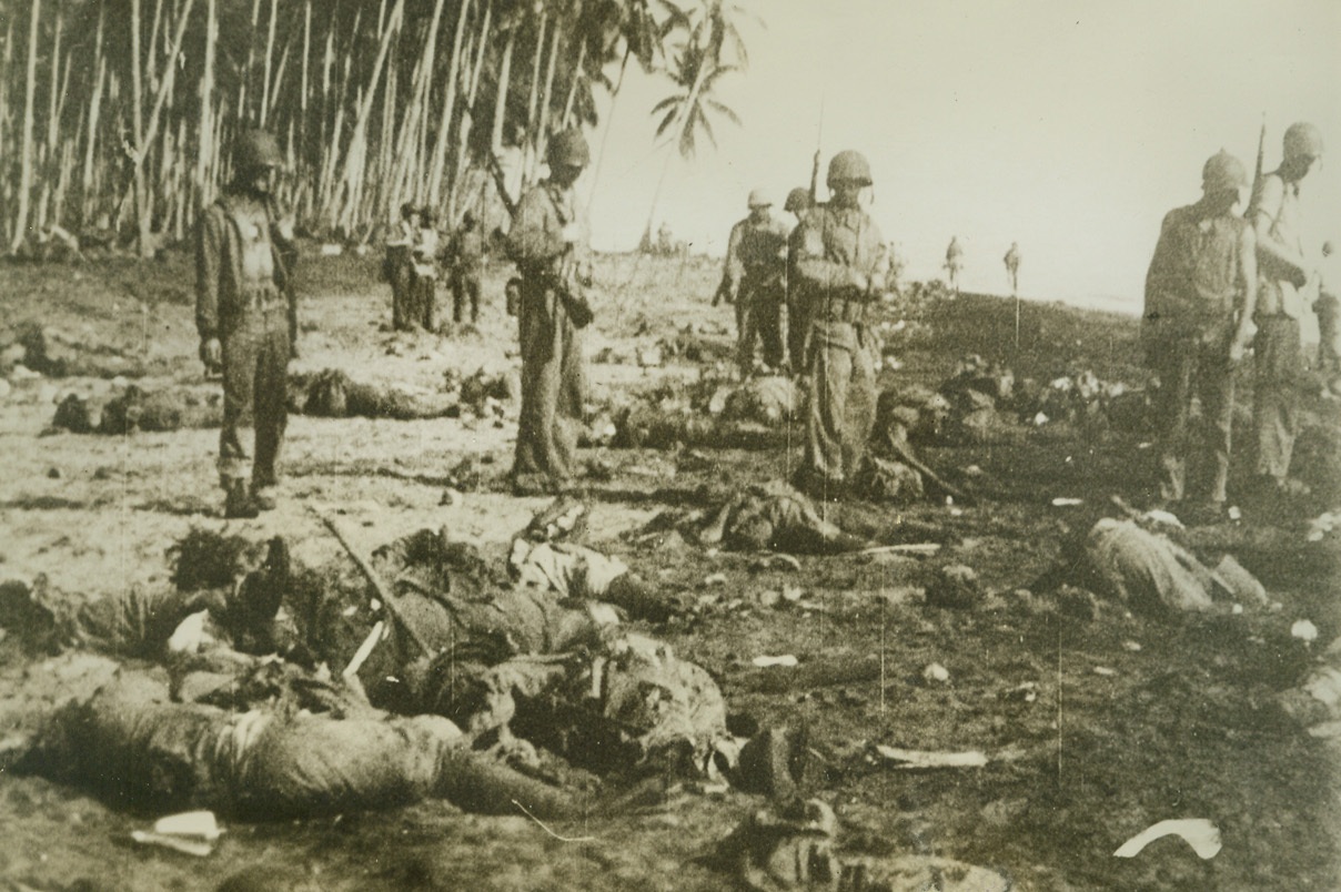 Dead Japs, 10/26/1942. Guadalcanal, S.I. – U.S. Marines look over the bodies of Jap soldiers on the beach at Guadalcanal, following a disastrous attempt by the Japs to land reinforcements.  The Marines, holding firmly to their newly constructed shore positions were too much for the invaders, who were annihilated as Yankee airmen blasted enemy ships and landing boats.Credit Line (Marine Corps Newsreel from ACME);
