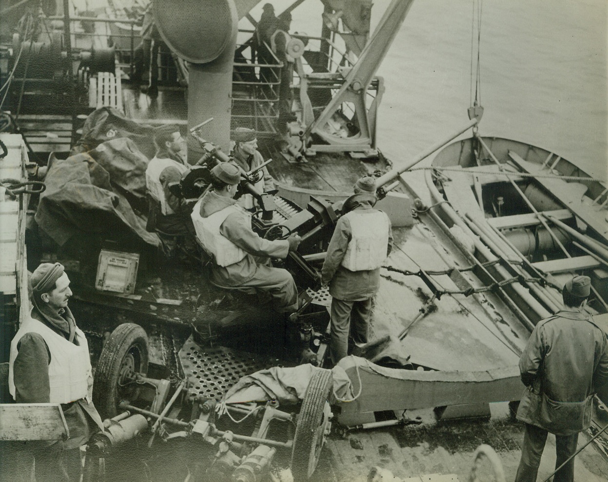 AMERICAN TROOPS LAND IN THE ALEUTIAN ISLANDS, 10/3/1942. WASHINGTON, D.C.—United States Army troops with Navy support have occupied the Andreanof Island group in the Aleutians, only 125 miles east of the Jap held Kiska it was announced by the Navy. Photo shows: a troop transport nears the landing beach while the gun crew aboard keeps a sharp lookout for enemy planes. Credit: U.S. Signal Corps photo from Acme;