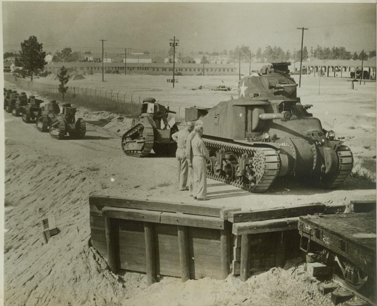 First World War Tanks Go to Scrap Heap, 10/5/1942. CAMP POLK, LA. – Like a mother caterpillar leading her youngsters, this modern medium American Armored Force tank starts Renault tanks of World War I on their trip to the blast furnace, where they will be converted into more modern war materials. The tanks were salvaged at Camp Polk, home of the 111 Armored Corps. Credit: (ACME);