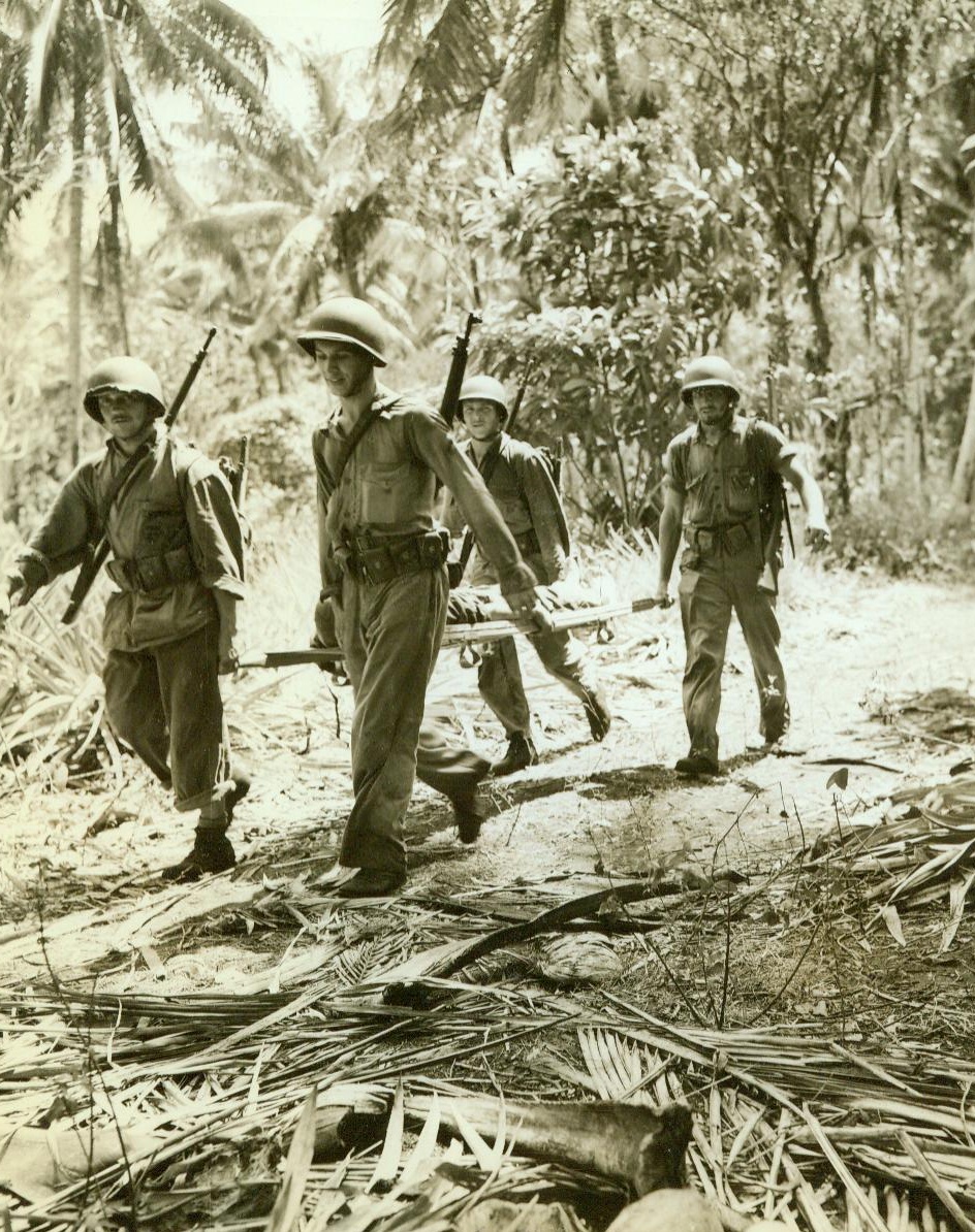 Unsung Heroes of Solomons, 10/29/1942. Guadalcanal – U.S. Navy Pharmacist Mates attached to the Marines as “Corpsmen”, act as stretcher bearers and give first aid to the sick and wounded while frequently under fire and in the midst of bombings. This crew is bringing in a wounded Marine through sweltering jungle heat and rain less than 100 yards behind front lines during an engagement between the Marines and an entrenched Jap patrol. 10/29/42 Credit Line (ACME);