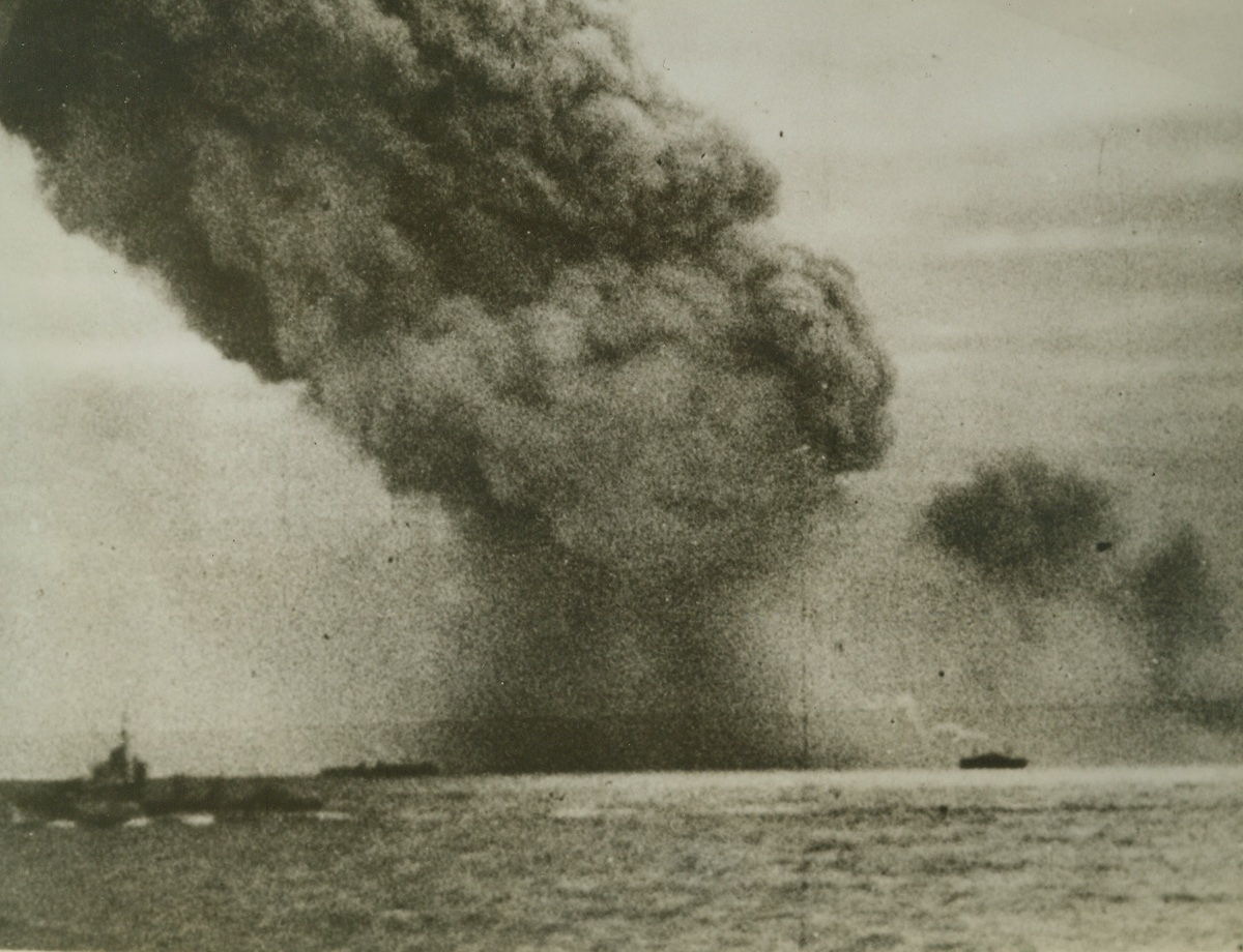 Allied Convoy Fights Through to Russia, 10/9/1942.  A pall of smoke rises from an Allied merchant vessel which was sunk during the four-day attack by Nazi torpedo planes and u-boats which intercepted the largest United Nations convoy attempting to reach a Russian Arctic port recently. Despite the intensive enemy action, the larger part of the convoy delivered its cargo intact. (Passed by Censors). Credit: ACME;