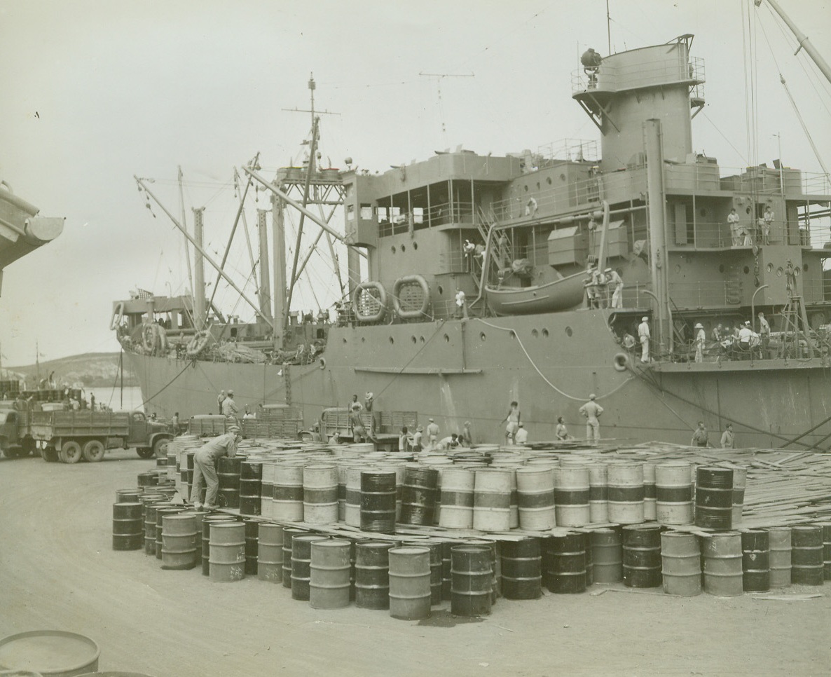 Supplies for the Solomons, 10/2/1942. South Pacifiic Port – Supplies of oil, together with foodstuffs, motors, and tractors, are loaded at a South Pacific port for shipment to the Solomon islands, where they will bolster U.S. Marine and Navy forces entrenched there. Credit line (ACME);