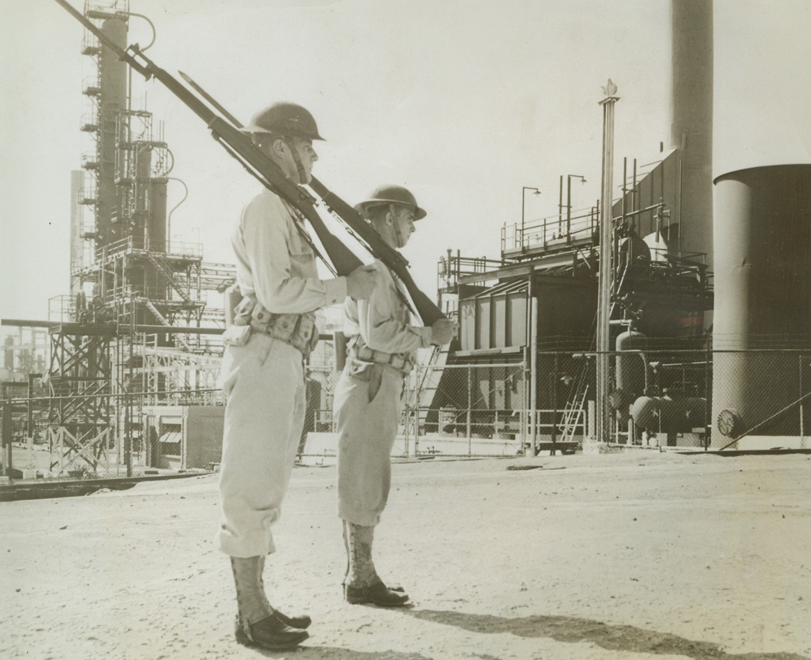 Uncle Sam Guards Dutch Oil on Aruba, 10/23/1942. Aruba Island, Dutch Guiana – Two U.S. soldiers stand guard before the enormous Lago oil refineries at Nicolaas, on Aruba island. Credit line (ACME);