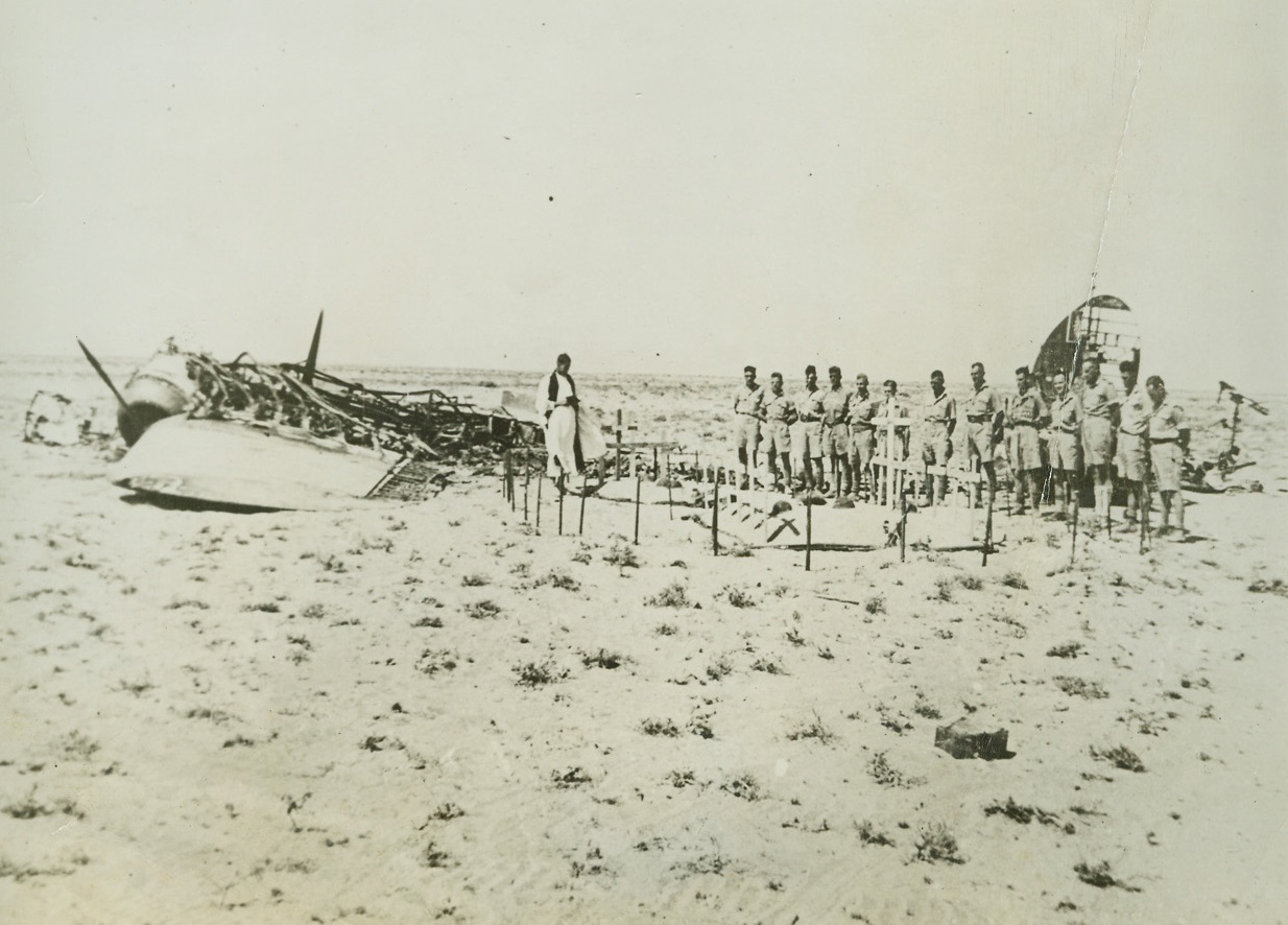 Desert Funeral Services for British Officer, 10/25/1942. Somewhere in Egypt – The scattered wreckage of the plane in which they met their death is an additional desert-graveyard marker for the final resting place of Lt. Gen. “Strafer” Gott and his men who died with him in the crash.  British soldiers stand soberly at attention as the funeral service is read.  Men who once fought with the deceased Lieutenant General are now pouring deep inside German lines in the new battle for North Africa. Credit line (ACME);