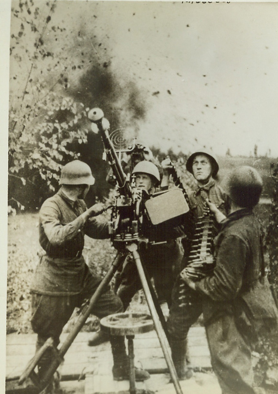 Soviet Ack-Ack Blast Nazi Bombers, 10/2/1942. Somewhere in Russia—A Red anti-aircraft crew keeps their aerial machine gun trained on German bombers that are attempting to blast the German battery. The Red crewman at the left appears to be gazing at a near Nazi bomb miss behind the group, while his companions’ attention is focused on the sky. Credit: ACME.;