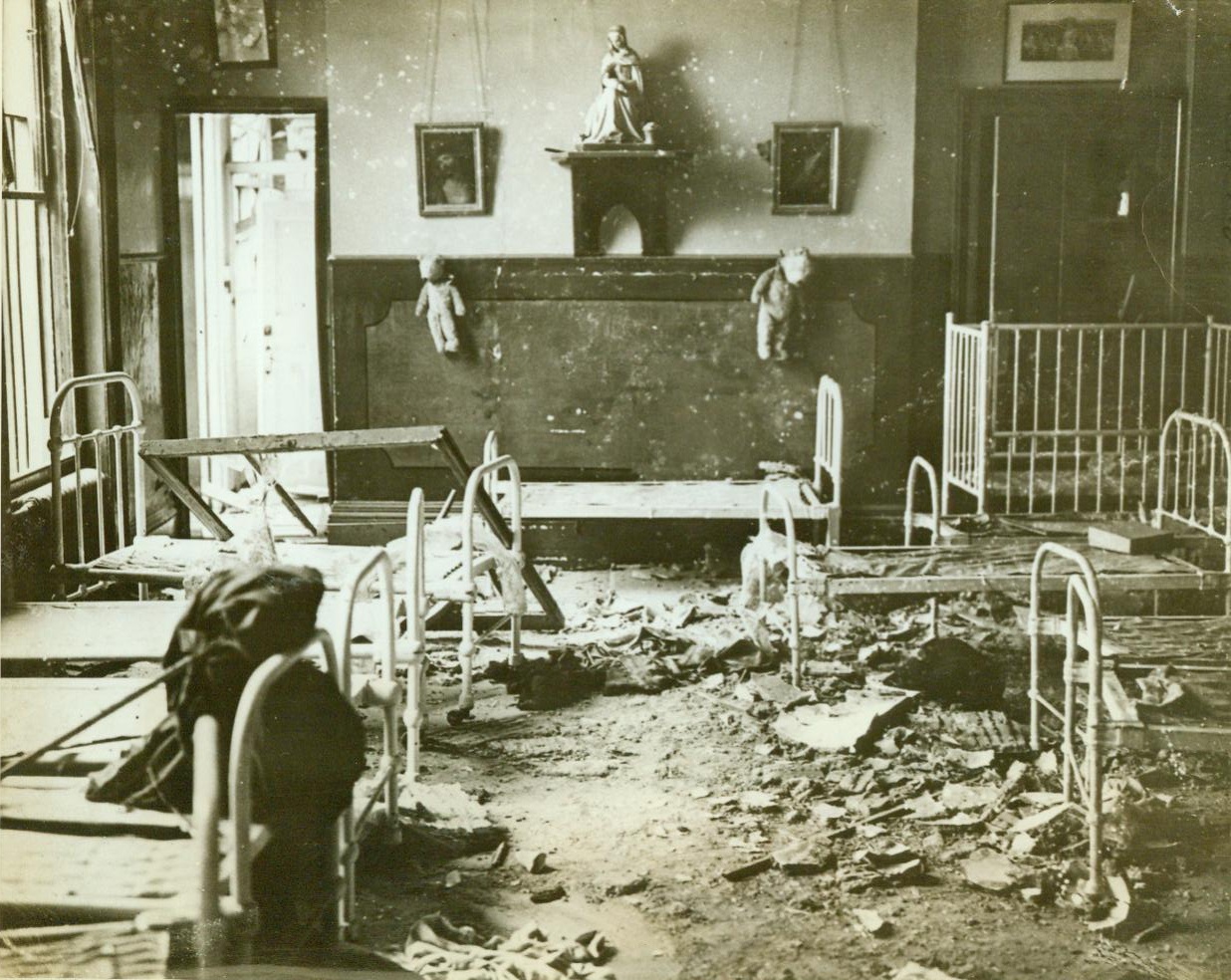 Crippled children’s home bombed, 10/21/1942. ENGLAND – One child was killed and five others injured when three Nazi sky raiders gunned and bombed a south coast convent and surrounding streets. Here are debris-covered cots in the dormitory of the convent that housed forty crippled children. Nuns braved the fire to carry them to safety in underground vaults. CREDIT LINE (ACME) 10/21/42;