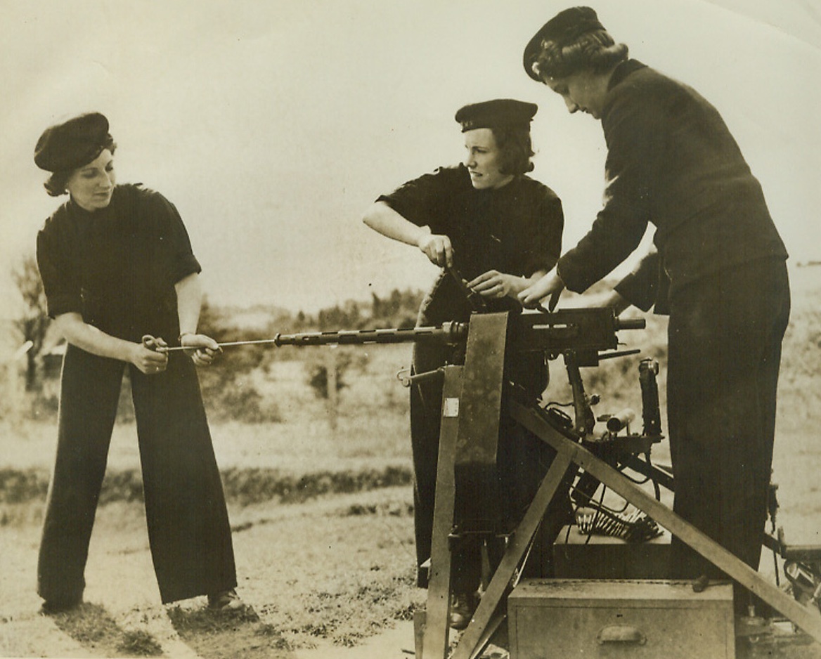 Wrens Service Machine Guns, 10/3/1942. England—Members of the Women’s Royal Naval Service, which operates with the Fleet Air Arm, clean a Browning machine gun at a Royal Naval Air Station in the south of England. Highly skilled, they work on radio equipment and service guns. (Passed by censor). Credit: ACME.;