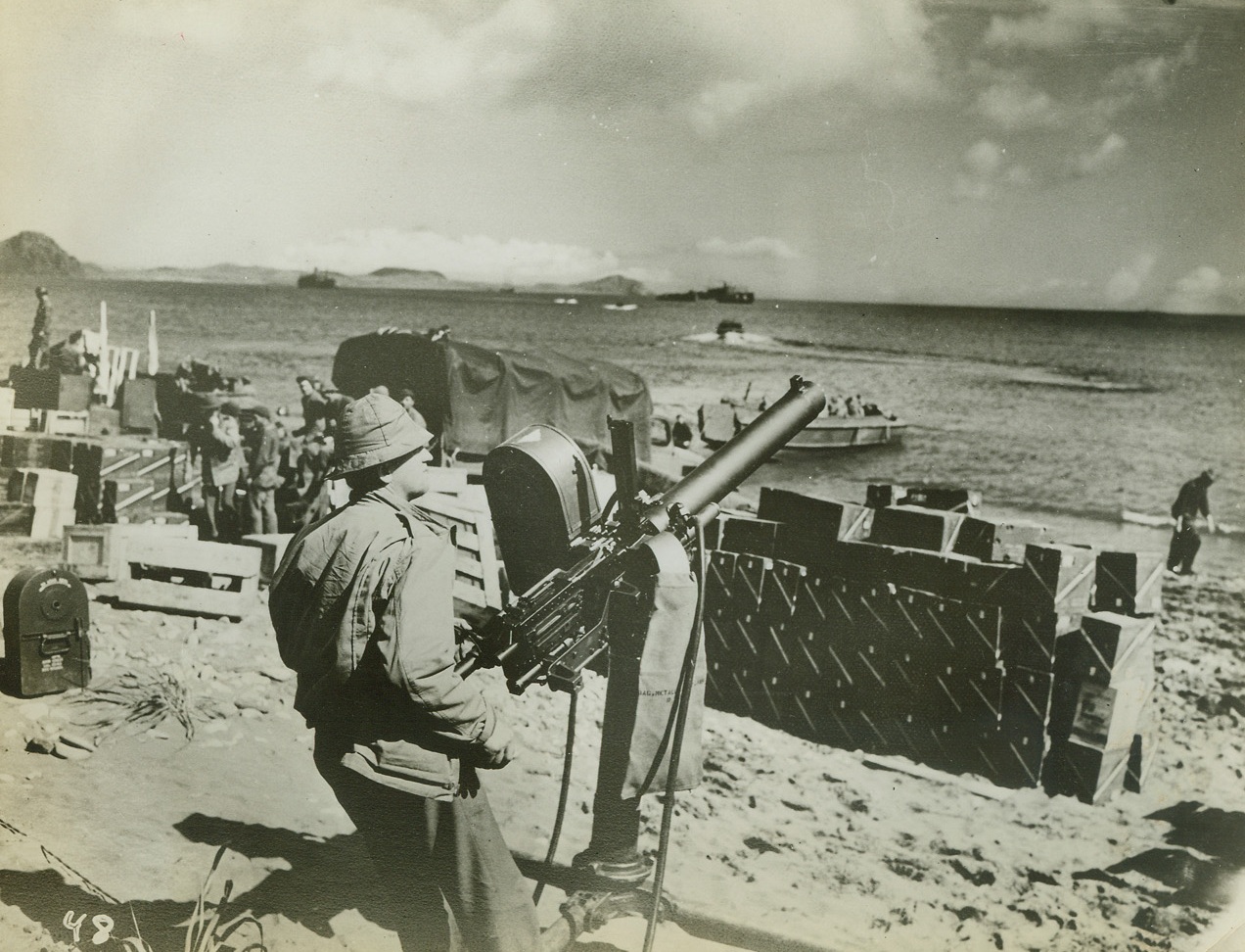 American Troops Land in the Aleutian Islands, 10/3/1942. Washington, D.C.—United States Army troops with Navy support have occupied the Andreanof Island group in the Aleutians, only 125 miles east of the Jap held Kiska it was announced by the Navy. Photo shows: a 50-caliber machine gun keeps a section of the beach well-guarded. The ammunition boxes in the background were removed shortly after this photo was taken.Credit: U.S. Signal Corps photo from ACME.;