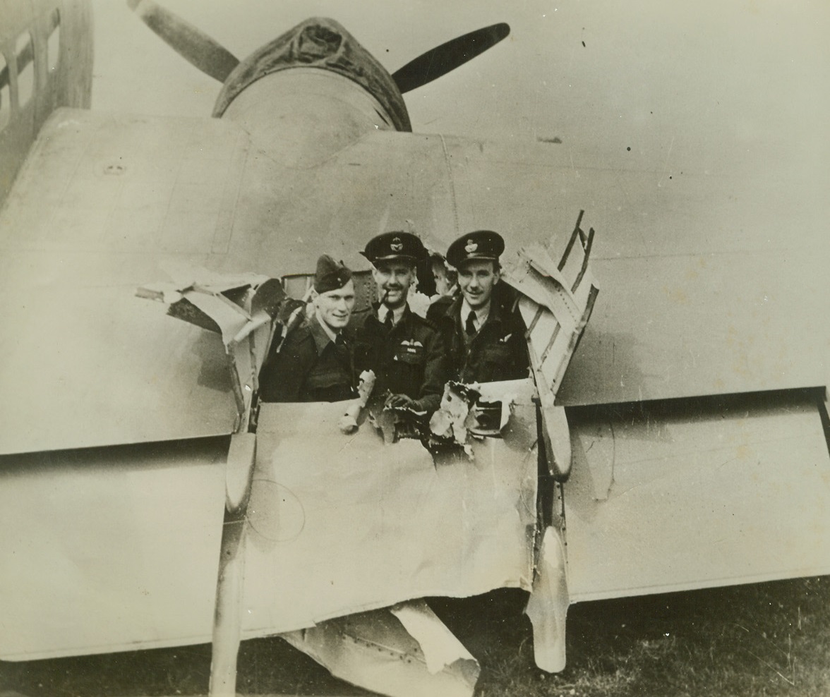 Shell Tears Hole in R.A.F. Bomber, 10/4/1942. England – The pilot and two crew members stand in the hold torn by a Nazi shell in the starboard wing of their Hudson Bomber. The R.A.F. Coastal Command ship was hit while attacking an enemy convoy stealing up the Dutch coast at night with supplies for Nazis on the Russian front. Despite the damage the pilot brought the ship home safely. Passed by censor. Credit: ACME;
