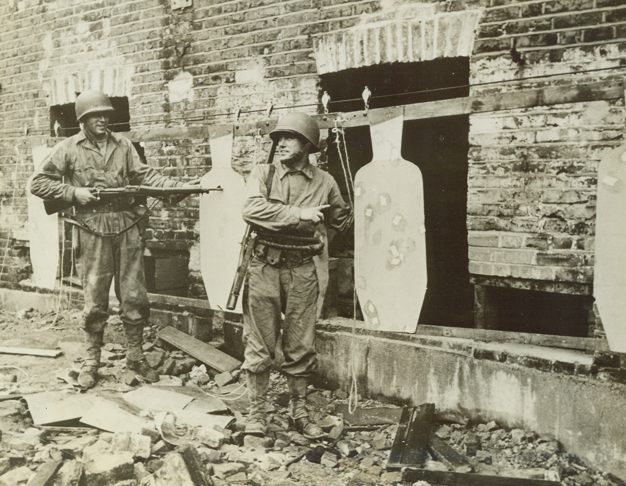 American Rangers Learn Street Fighting, 10/8/1942. London – With the blitzed areas of London a realistic city battleground, American Ranger Troops are mastering the technique of the brand of street fighting that now holds Stalingrad. Peppering targets while on the run, sniping, dodging, scaling ruined walls and using high explosives with lightning speed are now added to the long list of combat methods which make the United States Rangers ready for anything. (Passed by Censors) These bullet-riddled “snipers” were peppered by American Rangers 100 yards away on the run. Stationary and movable targets are blasted by combat units learning to take crack-aim from every conceivable shooting position. Credit: ACME;