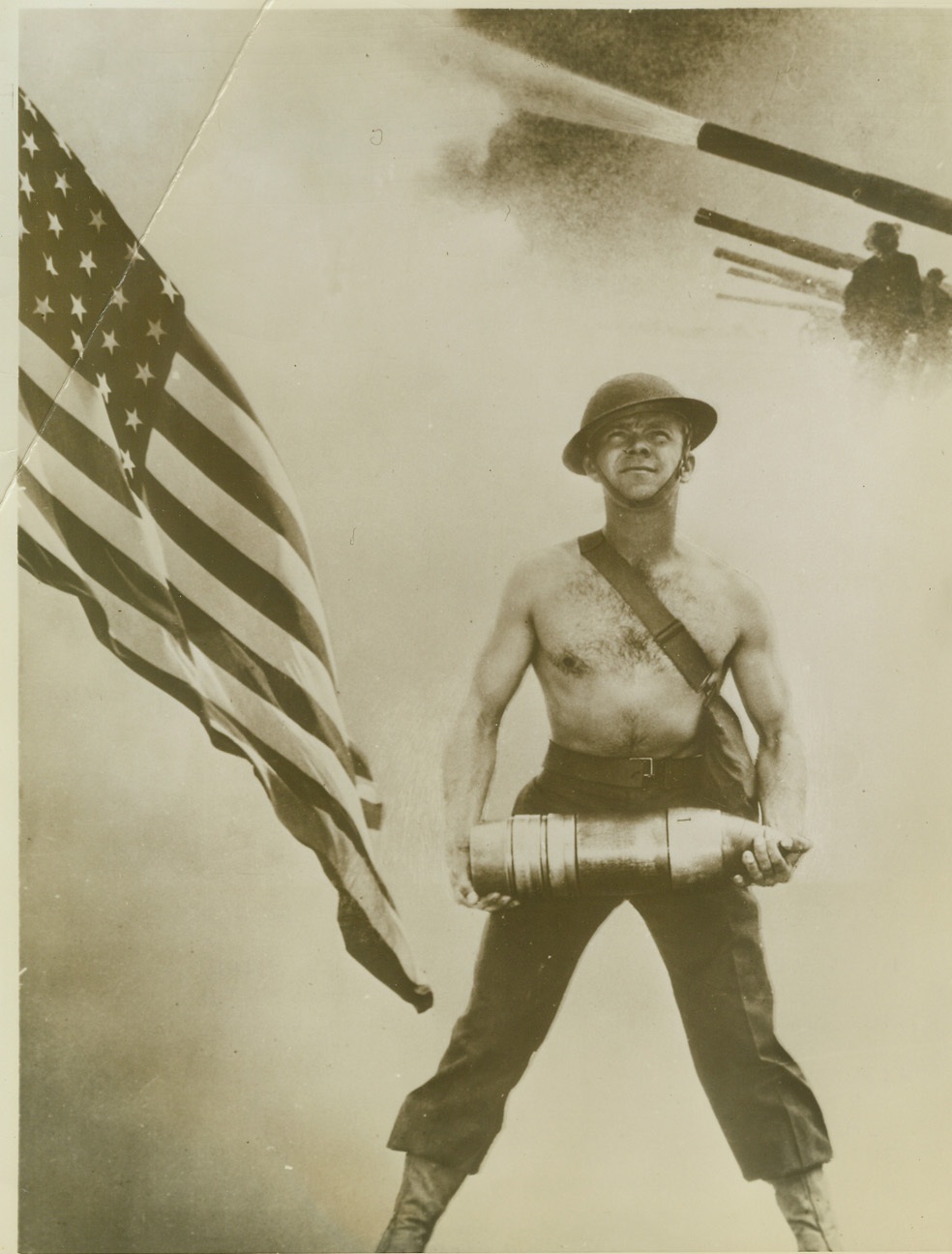 “And We’ll all be Free”, 11/6/1942. Camp Callan, Calif – A fighting Marine beside the Stars and Stripes and ready to “pass the ammunition” symbolizes observance of United States first wartime Armistice Day, next week. Sun-browned and tough-muscled, the Camp Callan soldier is joined by thousands of other fighting leathernecks battling for all the first Armistice results’ failed to accomplish. Credit: (ACME U.S. Army Photo);