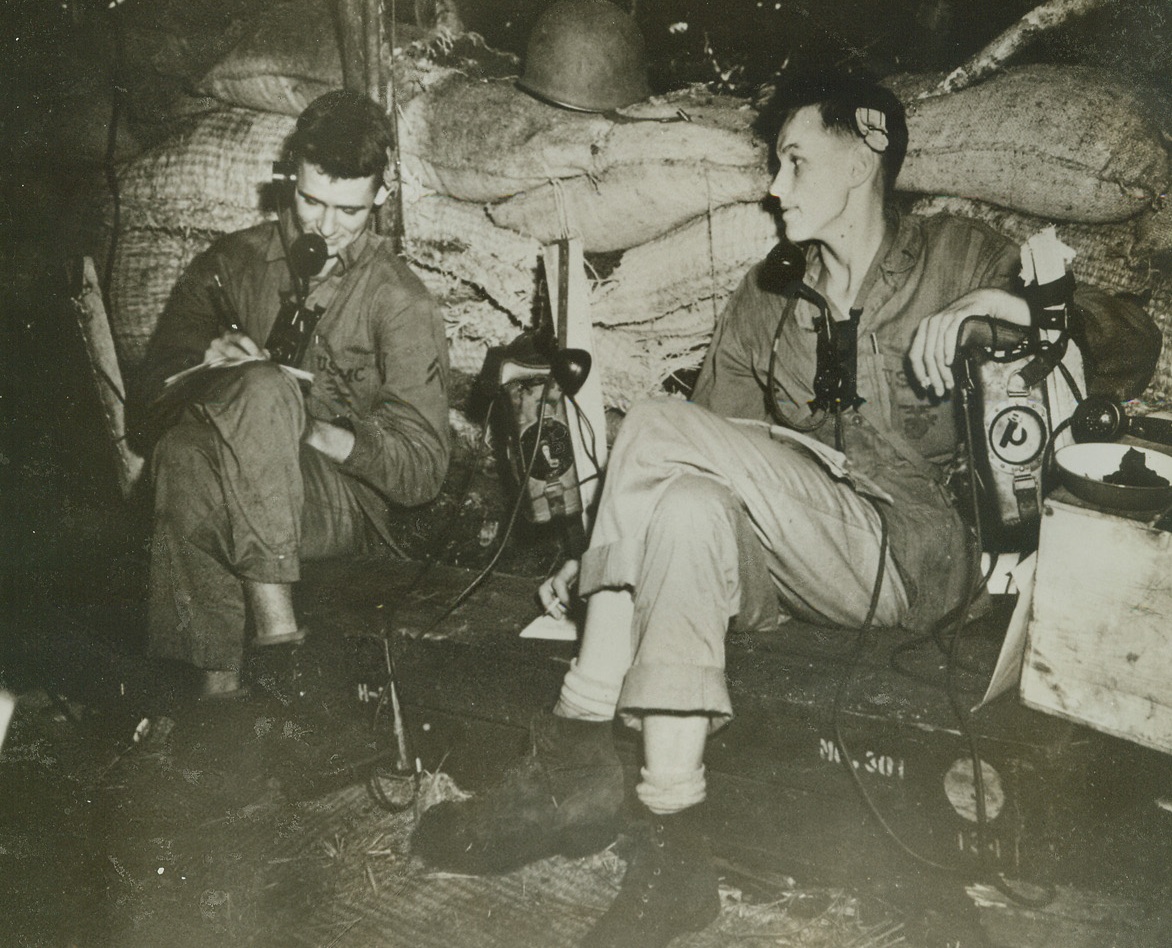 Guadalcanal Hot Spot, 11/4/1942. Washington, D.C. – Vital messages are relayed through this communications dugout located in a fighting zone, “somewhere in Guadalcanal.”  These Marines receive and transmit firing date, dispatches and other information needed by U.S. forces in their fight against the Japs.  Reports from the Solomons today, when this photo was released in Washington, indicate that Americans face heavy fighting by newly reinforced Nipponese troops on three sides of them.Credit Line (U.S. Marine Corps photo from ACME;