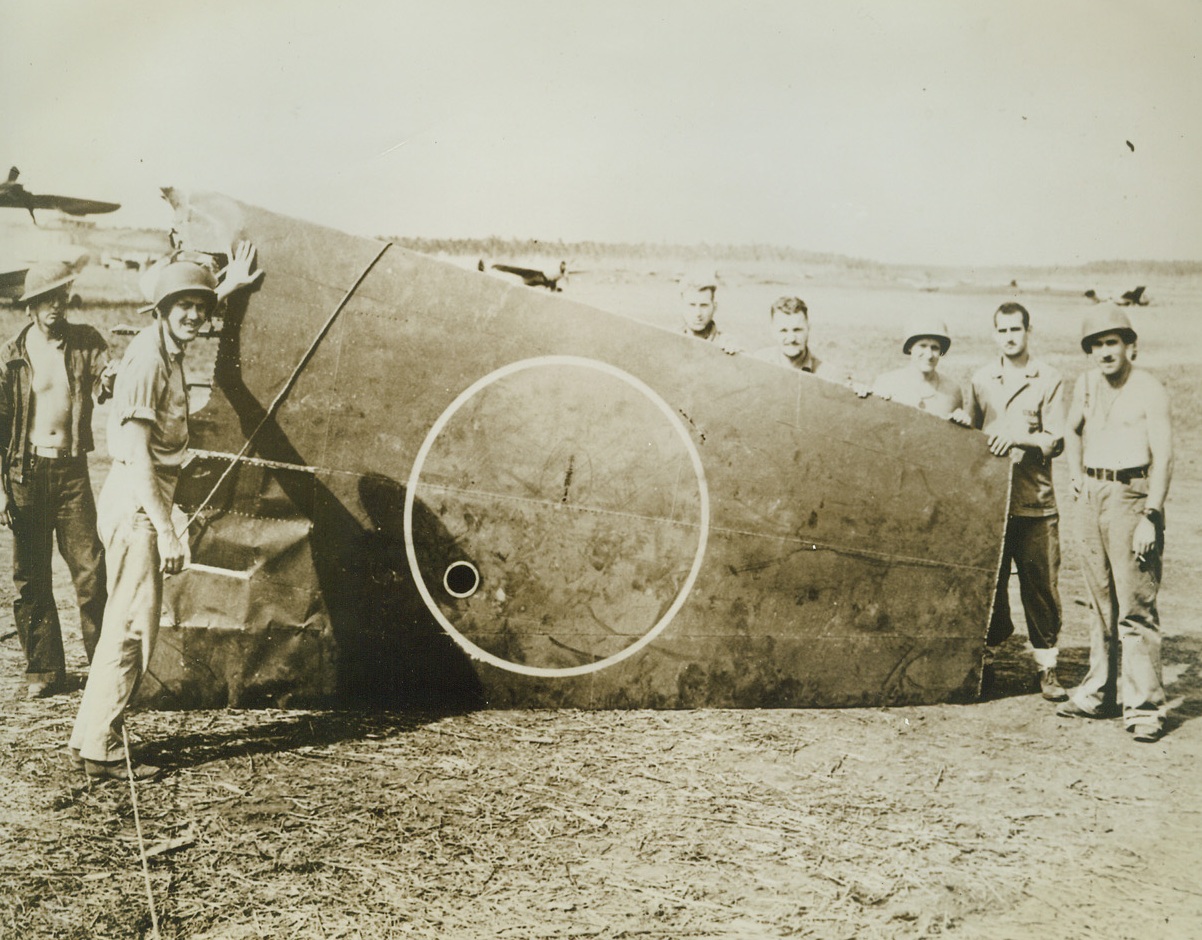 A Bit of Unrising Sun, 11/6/1942. Guadalcanal – Bits of a Jap bomber rained down on Marine-held Guadalcanal when a Leatherneck anti-aircraft shell touched off its ammunition load at 20,000 feet.  The dented wing-section was the largest single piece remaining of the Jap sky-raider.  Marines on besieged Henderson field, hold up their trophy. Credit (ACME Official U.S. Marine Corps photo);