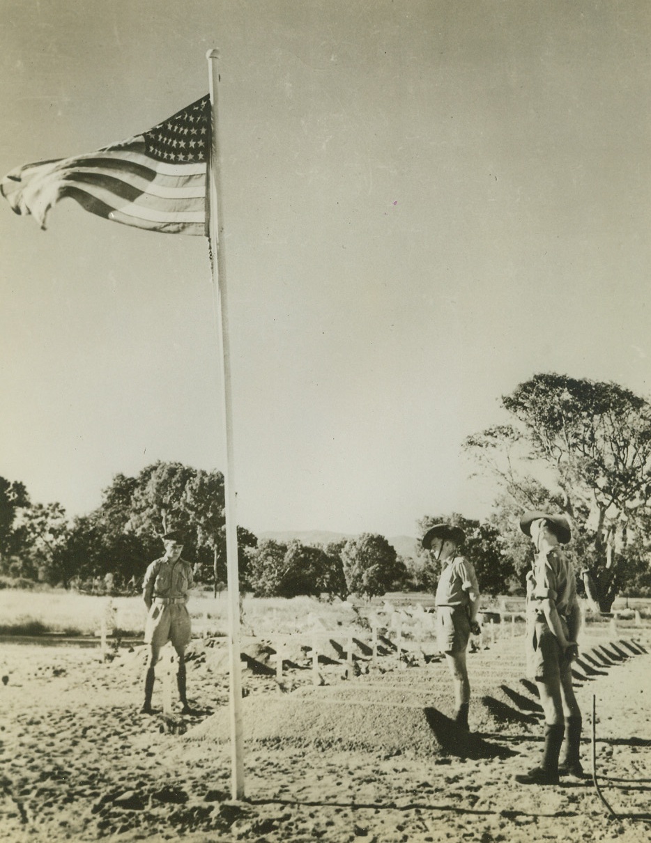 American Pilots Buried in Australia, 11/13/1942. Townsville, Australia – The stars and stripes wave above the American section of the military cemetery at Townsville, Australia, a soldier colony.  The graves are mostly of U.S. airmen, killed in action, and are cared for by Australian soldiers, three of whom are shown. Credit line (ACME);