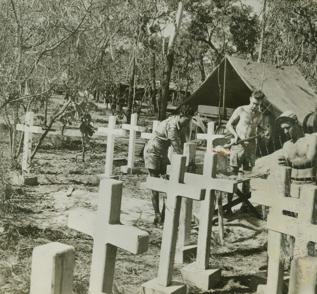 American Graveyard Near Darwin, 11/3/1942. Darwin, Australia – In the heart of the jungle near Darwin, Australia, soldiers mix cement for the crosses to mark graves of U.S. Airmen who died in battle.  Wooden crosses didn’t last long over the final resting places of the fighting pilots who were killed in air combat with Jap raiders. Credit line (ACME);