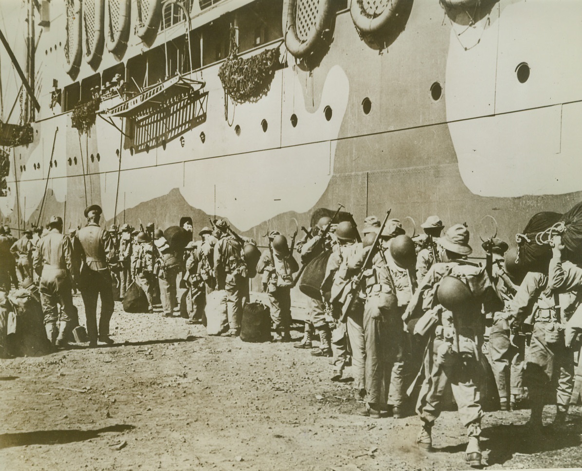 Army Reinforces Marines in Solomons, 11/4/1942. Washington, D.C. -- This photo, just released in Washington, shows a U.S. Army Task Force boarding a transport at New Caledonia, just before it left to reinforce U.S. Marines, who are engaged in bitter fighting with the Japs in the Solomon Island area. Credit: U.S. Army photo from ACME;