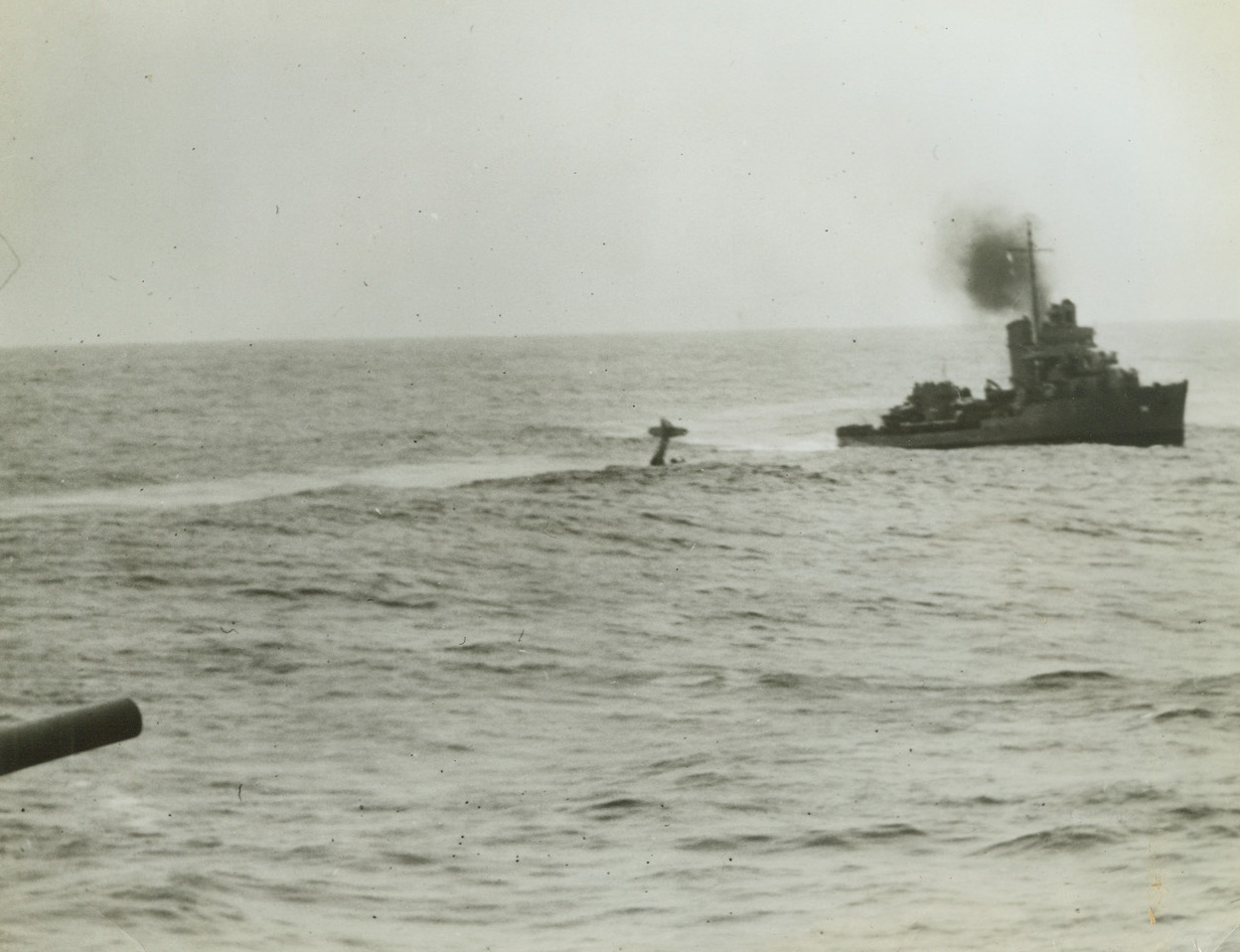 Flyers Take Dunking, 11/4/1942. A destroyer maneuvers to rescue the crew of a U.S. Navy plane which missed its landing on the carrier belonging to gun at extreme left. The airmen are barely discernible at right of plane. Credit: Official U.S. Navy photo from Acme;
