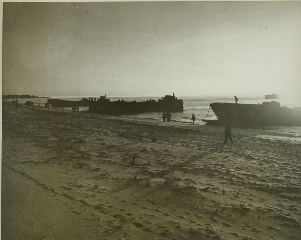 Amphibian Engineers Come Ashore (4), 12/20/1942. Camp Carrabelle, Fla.—Landing craft of the Amphibian Engineer Command are shown beached on the Gulf of Mexico shore at sunrise during landing maneuvers. Credit: ACME.;