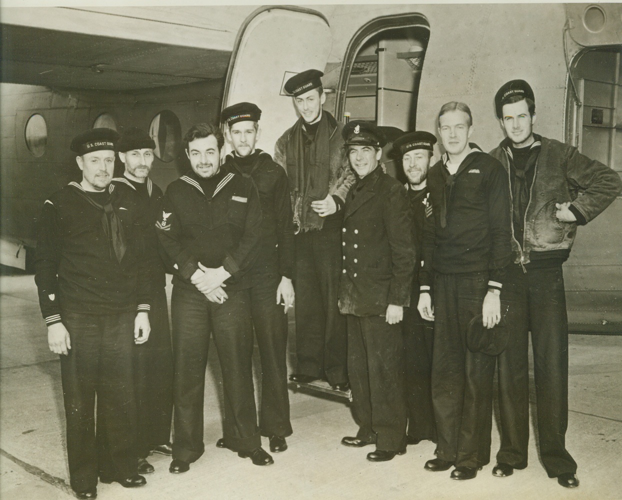 STOOD OFF DAVY JONES FOR THREE LONG WEEKS, 12/24/1942. NEW YORK CITY, NEW YORK – They are nine battered members of the Coast Guard Reserve. They were battered about the Atlantic in their fifty-eight-foot yawl, a slim craft built for racing, for twenty-one days. They were swept helplessly before winds of hurricane force that carried them 3,100 miles from a point more than 100 miles off a Canadian port to Cape Hattoras, N.C. They were rescued today thanks to the vigilance of officers and men of the Eastern Sea Frontier. They are shown above on their arrival at the U.S. Naval Air Station (Floyd Bennett Field). They were flown from Ocracoke Inlet, N.C. – where they were brought after their rescue – to Elizabeth City in a Coast Guard plane. At Elizabeth City they were transferred to a Naval transport plane which, after a stop at Norfolk, brought them here. Left to right they are: Arnold Windsor, Greenport, L.I., N.Y.; James T. Watson, of Greenport, L.I., N.Y.; Vance M. Smith, of Swampscott, Mass.’ Toivo Koskinen, of Bridgeport, Conn.; Ward Weimar, Greenwich, Conn.’ Curtis Arnall, of Greenport, L.I., N.Y. the skipper of the craft; Theodore C. Carlson, North Baltimore, L.I., N.Y.; Joseph E. Choate, Brooklyn, N.Y., and Edward R. Jobson, Larchmont, N.Y. They’ll be home for Christmas. Credit: ACME;