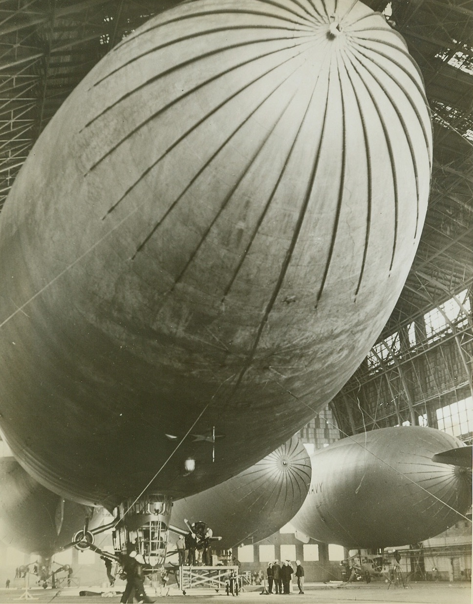 They Annoy Subs, Too, 12/30/1942. LAKEHURST, N.J. -- Nestled in their huge hangar for servicing by ground crews are four of the U.S. Navy's "K" type lighter-than-air ships. This type blimp is used for squadron duty and has played a prominent role in anti-submarine warfare off the Atlantic coast. Credit (Official Navy Photo - ACME);