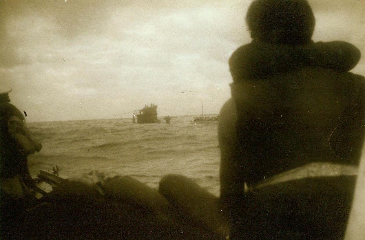 Torpedoed Ship’s Skipper Taken Prisoner, 12/29/1942. At Sea: -- A crew member of an Allied merchantman torpedoed by a German U-boat somewhere in the South Atlantic snapped this picture from the liferaft in the foreground. From the lifeboat in background, the Captain and Engineer of the sunken ship were taken prisoners by the U-boat commander and brought aboard the submarine. Which can be seen to left of Lifeboat. 12/29/42 Credit Line (ACME);