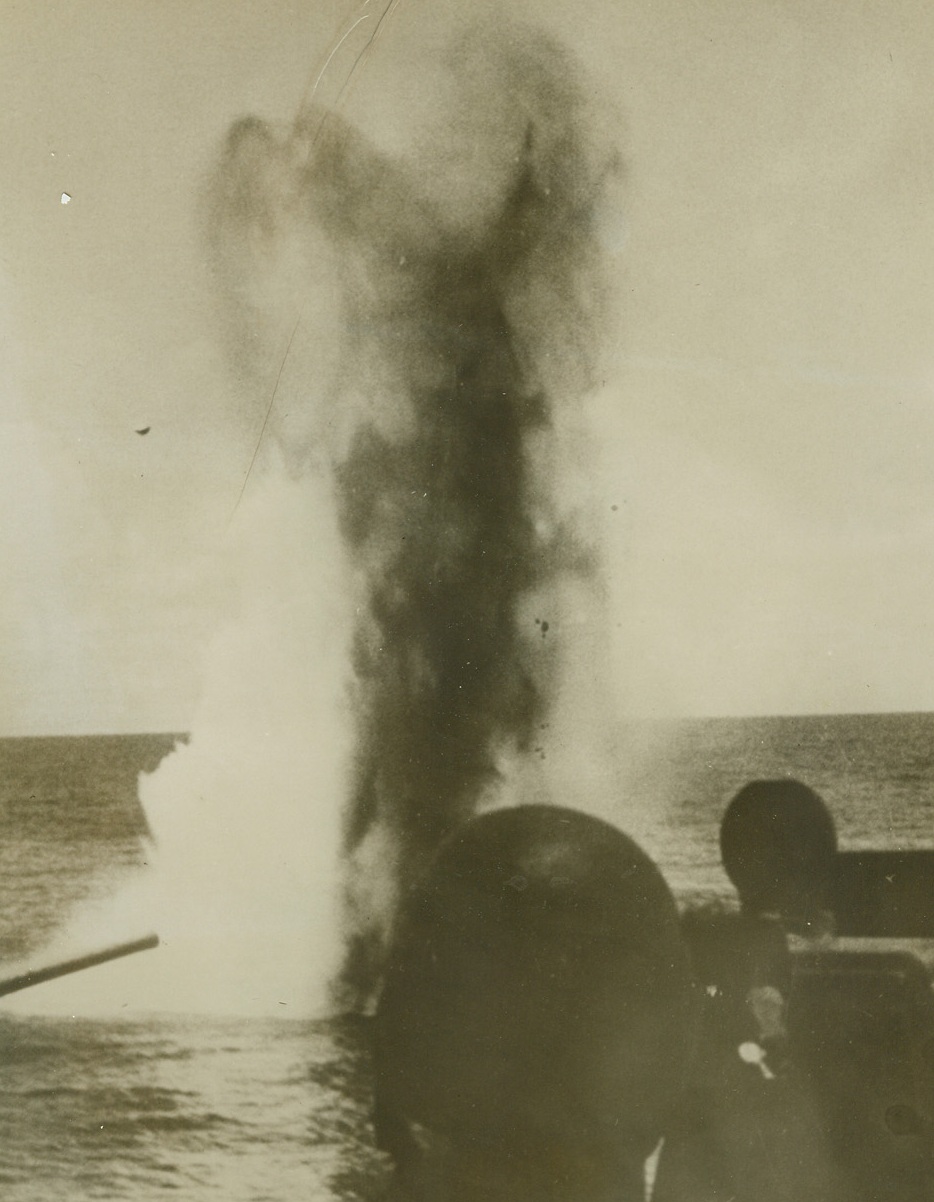 No Title. 12/22/1942. This photo, taken from a newsreel, shows a column of smoke and water rising from an exploding bomb dropped near an American aircraft carrier during recent action in the South Pacific. Not one U.S. ship was more than slightly damaged in the action in which a Japanese bombing fleet was driven off. This picture has just been released in New York.  Credit: U.S. NAVY PHOTO FROM ACME;