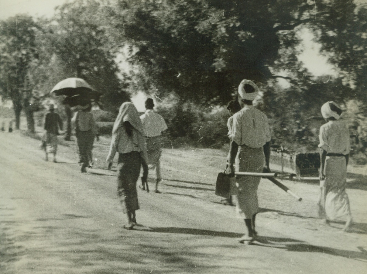 Jap Methods, 12/14/1942. Burma –This tiny draped coffin and digging implements carried by a Burmese family tells the story of a Jap terror raid.  The group walks from their bombed village after a blitz from the air which was merely one of those axis affairs calculated to clog roads with panic-stricken refugees. There was no possibly military objective in the little village. Credit line (ACME);