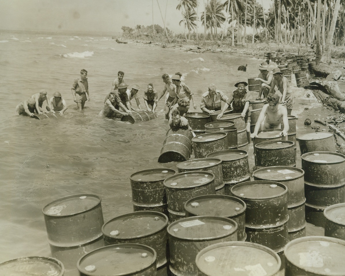 Fuel to Blast the Japs, 12/29/1942. New Guinea: - Australian troops gather gasoline drums which were dropped over the side of a United Nations supply ship to stock an allied base in New Guinea.  This is but a token of the supplies needed to blast the Japs out of the island. Credit line (ACME);