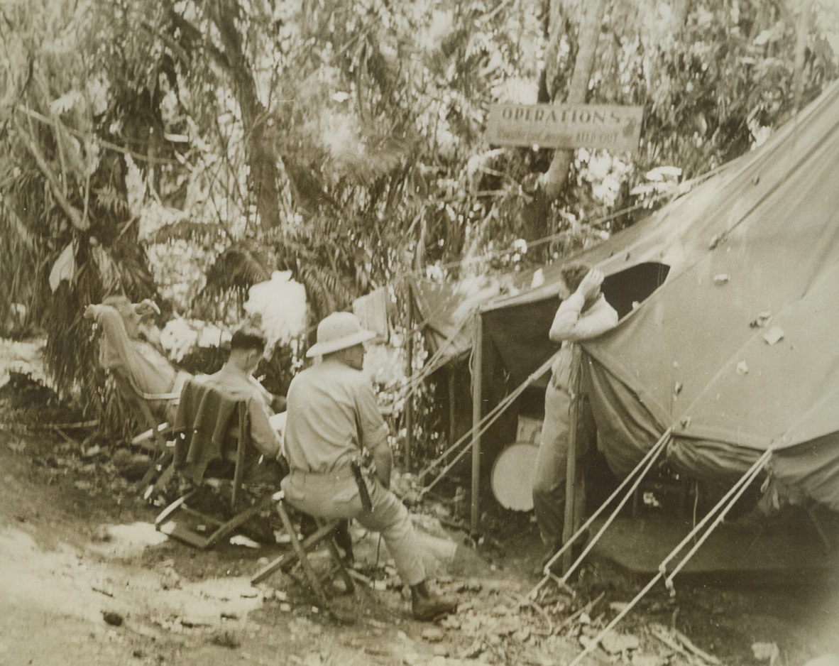 Waiting for Orders, 12/21/1942. Guadalcanal – Near this tent deep in a jungle on Guadalcanal island, these operations officers “stand by” for orders.  From this point, battle orders are issued to various combat groups on the island.  Seated in the foreground is Col. Lawson H.M. Sanderson, USMC Credit line (U.S. Navy photo from ACME);