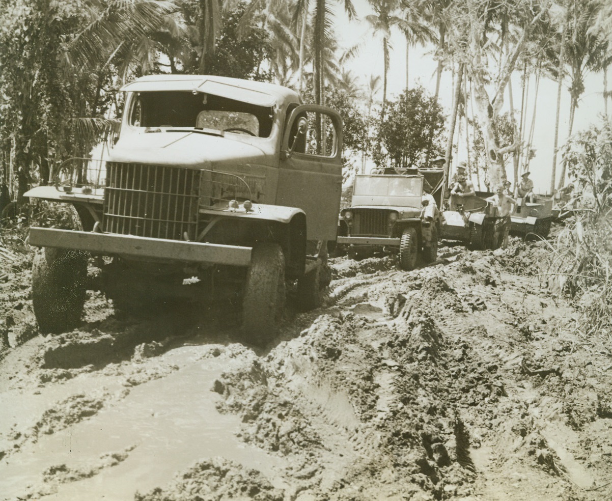 Weather Clear, Track Muddy, 12/29/1942. New Guinea: - The skies had cleared, but the roads were muddy after a heavy rain in New Guinea.  But these American Army trucks easily negotiated the sloppy land to deliver supplies to our boys. Credit line (ACME);