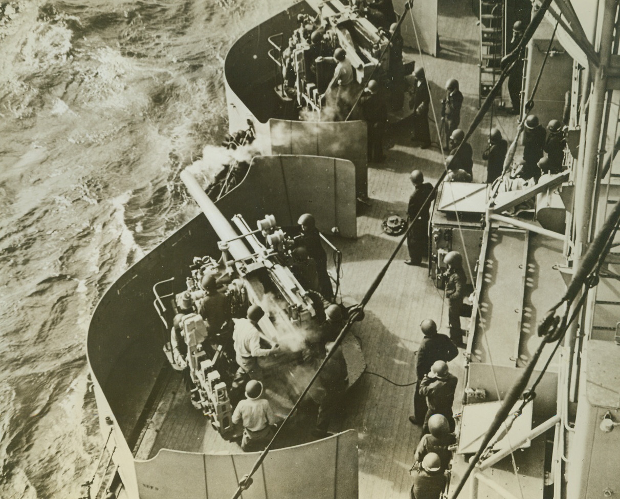 Testing Five-Inch Gun Battery, 12/11/1942. This photo taken during the occupation of North Africa by Anglo-American forces, shows gunners aboard a cruiser, testing a five-inch gun battery as the vessel neared the North African coast.  Picture was just released in New York today. Credit line (ACME);