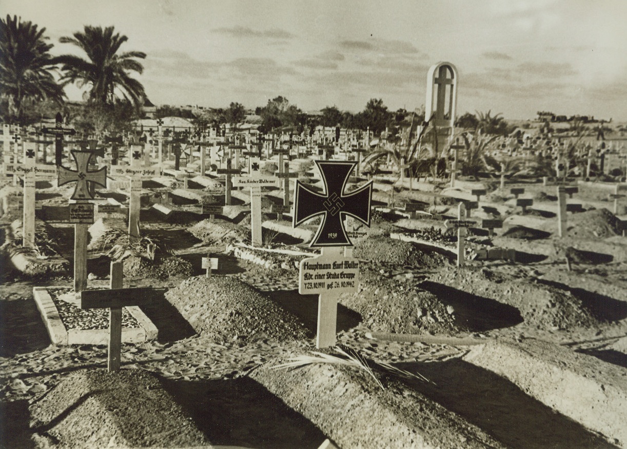 Members of “Master Race” Wound Up Here, 12/16/1942. Mersa Matruh, Egypt - - Elaborate grave markers in this axis graveyard at Mersa Matruh, show where many of Hitler’s Afrika Korps found “the end of the road.”  In center, (foreground), a marker bearing a replica of the iron cross, indicates the grave of Hauptmann Kurt Walter, Commander of a Stuka dive bomber squadron, who died three days after his 31st birthday, in the battle of El Alamein.  Though only Germans were buried in this cemetery, Italians did most of the work in building it.  Germans have been buried, in most cases, far away from the Italians.  This held true until recently, when Britain’s 8th Army sent Rommel into headlong retreat and burials became occasions of little ceremony. Credit line (ACME);