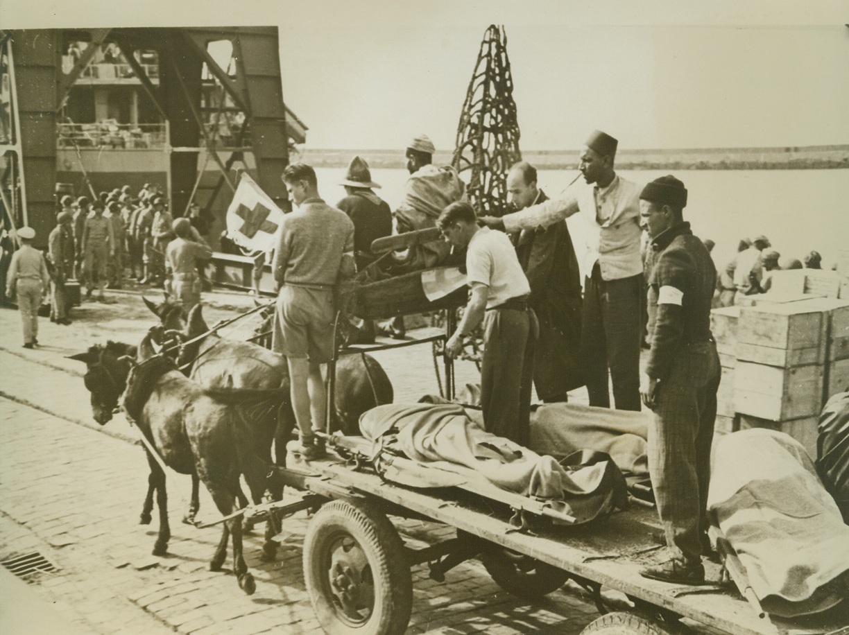 BODIES ON DOCK AT SAFI, 12/11/1942. This photo taken during the occupation of North Africa by Anglo-American forces, shows bodies on stretchers being transported across a dock at Safi. Caption on this pictures, just released in New York today, does not identify the dead either as French or American.Credit Line (ACME);