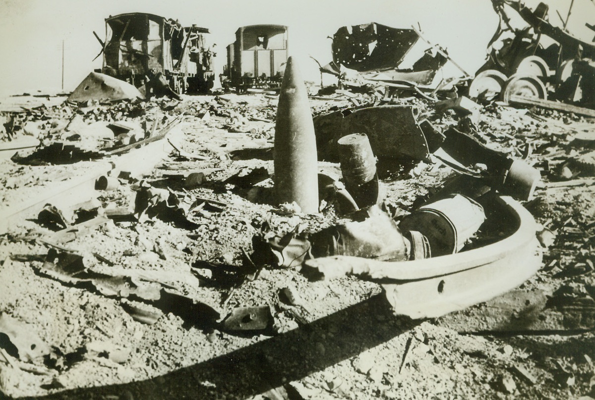 Rebuilding Desert Railway (#2), 12/9/1942. At this spot at Simla, near Mersa Matruh, are the remains of an Axis ammunition train hit by Allied bombers. Explosion ripped up much of the roadbed and presented a large problem for Allied engineers who repaired the railroad after the British recaptured the rail section. This photo just reached New York. (Passed by censors).Credit: ACME;