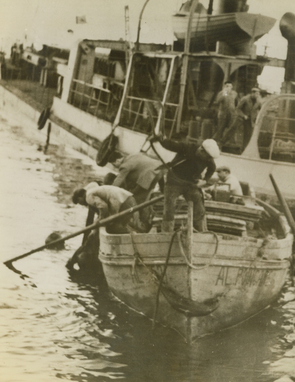 Rescued from Sunken Tank, 12/26/1942. Algiers—When U.S. General Grant tanks were being unloaded at Algiers, one fell into the water. Two of the crew swam ashore, but the third went down to the rescue and this photo shows him bringing the crewmen up.Credit: ACME.;