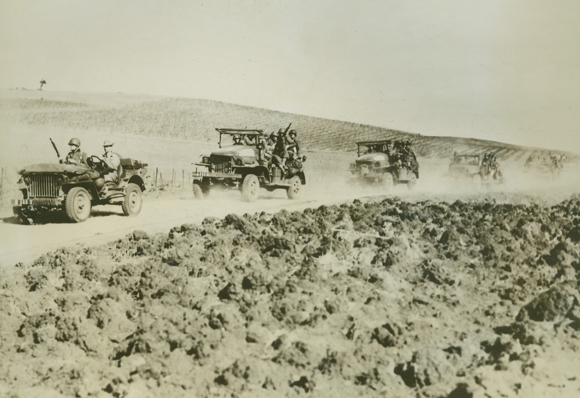 U.S. Speeds Through Algeria, 12/18/1942. Algieria—United States motorized columns advance rapidly through Algeria on their way to new battlefronts. They are probably heading toward the Tunis area where, at the present time both Nazis and Allies are bringing up reinforcements as good weather indicates that new, heavier battles may be expected. Credit: ACME.;