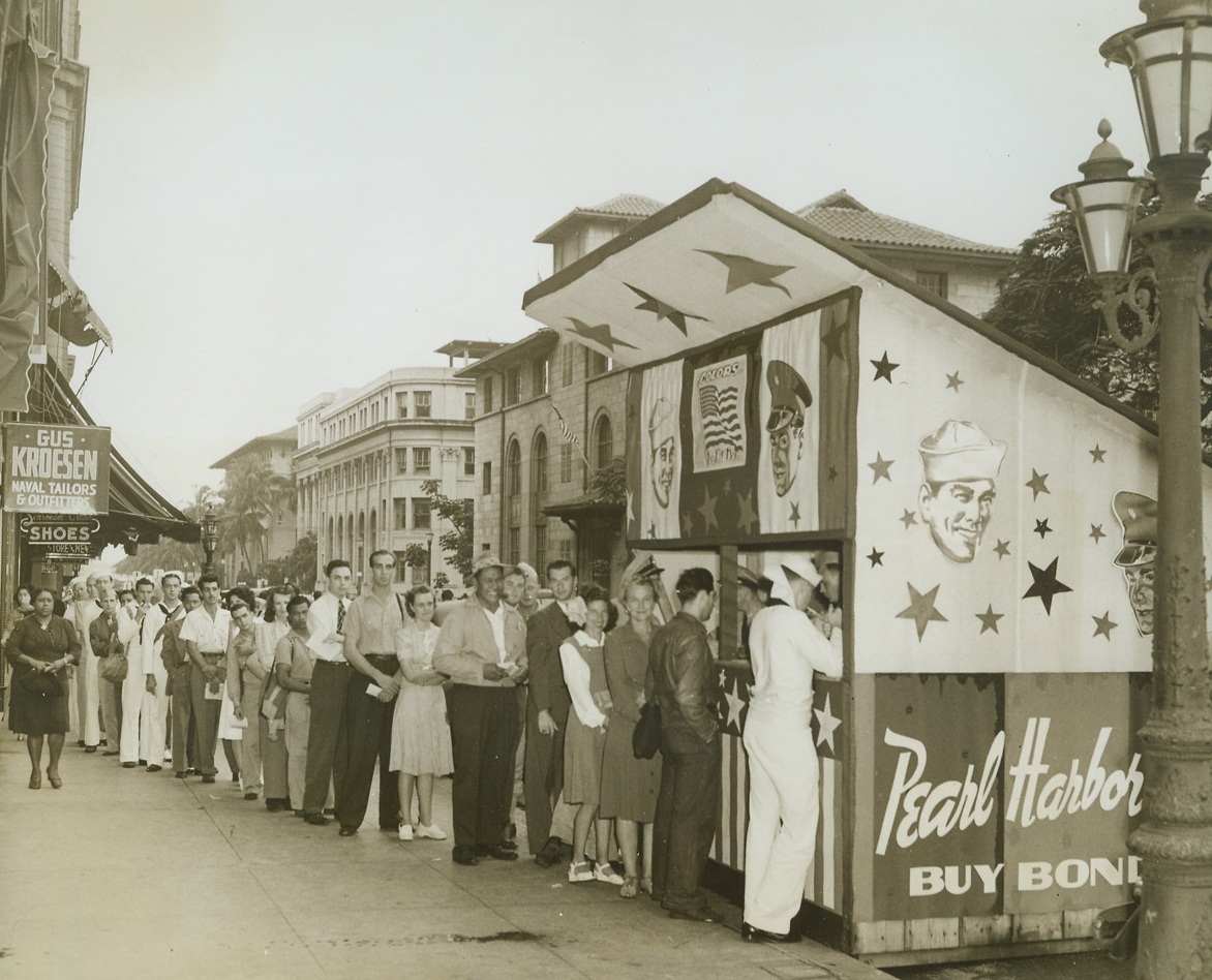 They Said It With Bonds, 12/16/1942. Honolulu, Hawaii—Hawaii remembered Pearl Harbor on the anniversary of the Japs’ treacherous attack by buying bonds—three and a half million dollars worth. One of the many lines that formed in Honolulu on December 7, 1942, by bond-buyers is shown. Crowds jammed the streets where 15 bond booths did land office business selling bonds stamped with the souvenier stamp, Remember Pearl Harbor.Credit: ACME.;