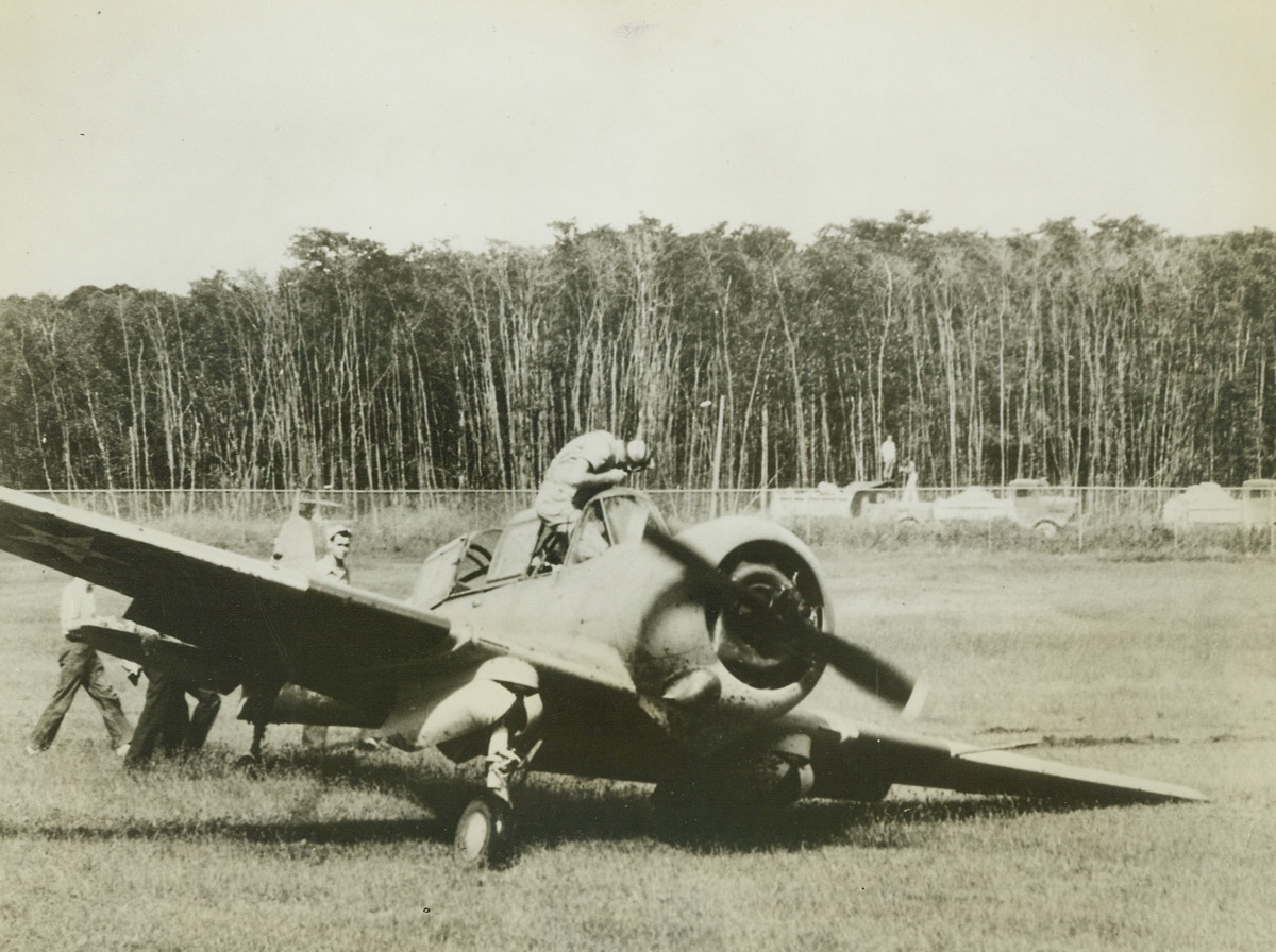 Ticklish Landing, 12/18/1942. After making a slanted, dangerous landing with one wheel up and the other down, the pilot crawls out of the cockpit of a Navy SNC plane. There are two tributes to the skill of the pilot in this picture—he is under his own power, and the craft is not badly damaged. The landing he made was almost impossible to execute without heavy damage. Credit: Official U.S. Navy photo from ACME;