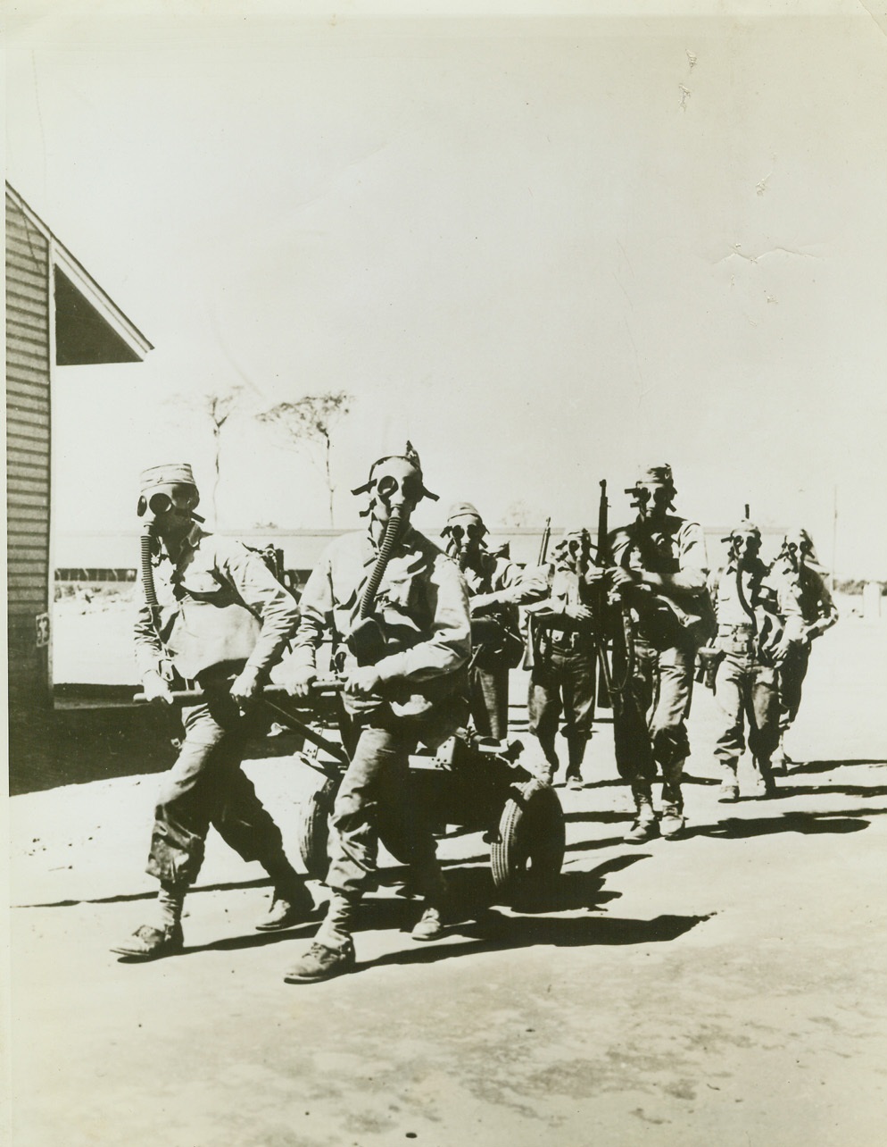 With U.S. Army in Trinidad, 2/27/1942. Trinidad—U.S. Army troops stationed in this West Indies base go through exercises with mounted machine guns while accustoming themselves to wearing their gas masks. Credit: U.S. Army Signal Corps from ACME.;
